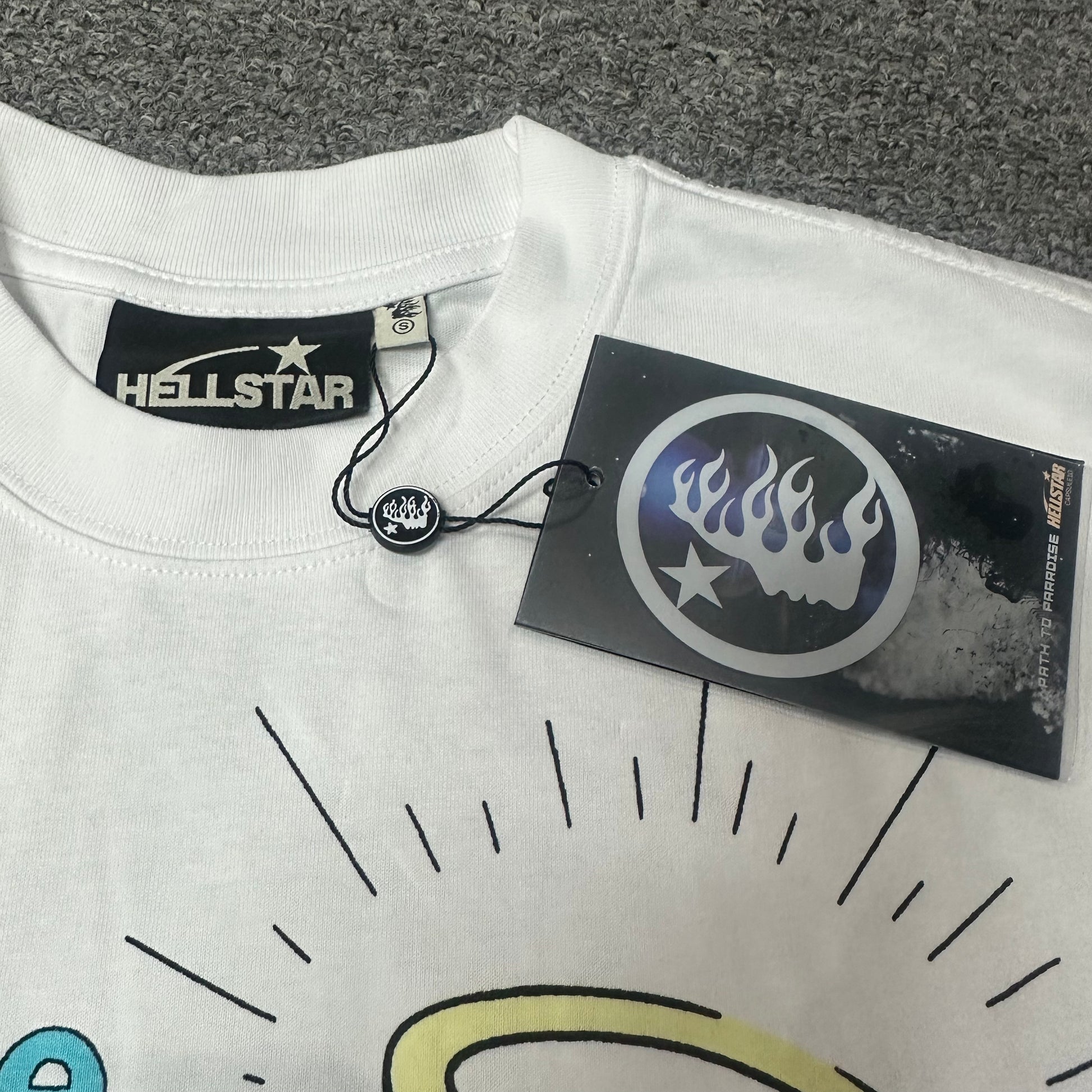 Crew neck stitching detail on Hellstar Paradise Lambs white graphic T-shirt
Hellstar woven neck label inside the Paradise Lambs white graphic T-shirt
Hellstar size label detail inside the Paradise Lambs white T-shirt
Hellstar branded hangtag attached to the Paradise Lambs white graphic T-shirt
