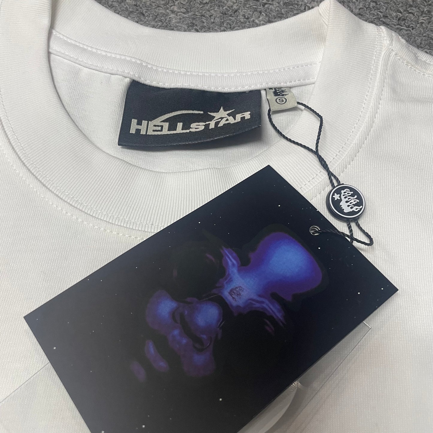 Crew neck collar and stitching detail on Hellstar H Blue Flame T-shirt
Hellstar woven neck label inside H Blue Flame white T-shirt
Hellstar size label detail inside H Blue Flame white T-shirt
Hellstar branded hangtag attached to H Blue Flame white T-shirt