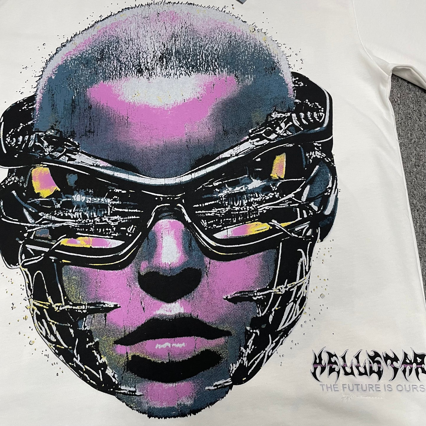 Full futuristic face and layered goggles graphic on Hellstar white T-shirt
Close-up of the futuristic goggles face print on Hellstar graphic T-shirt
Detailed pink blue yellow and black graphic print on Hellstar Goggles Tee
Layered futuristic goggles artwork detail on Hellstar graphic T-shirt
