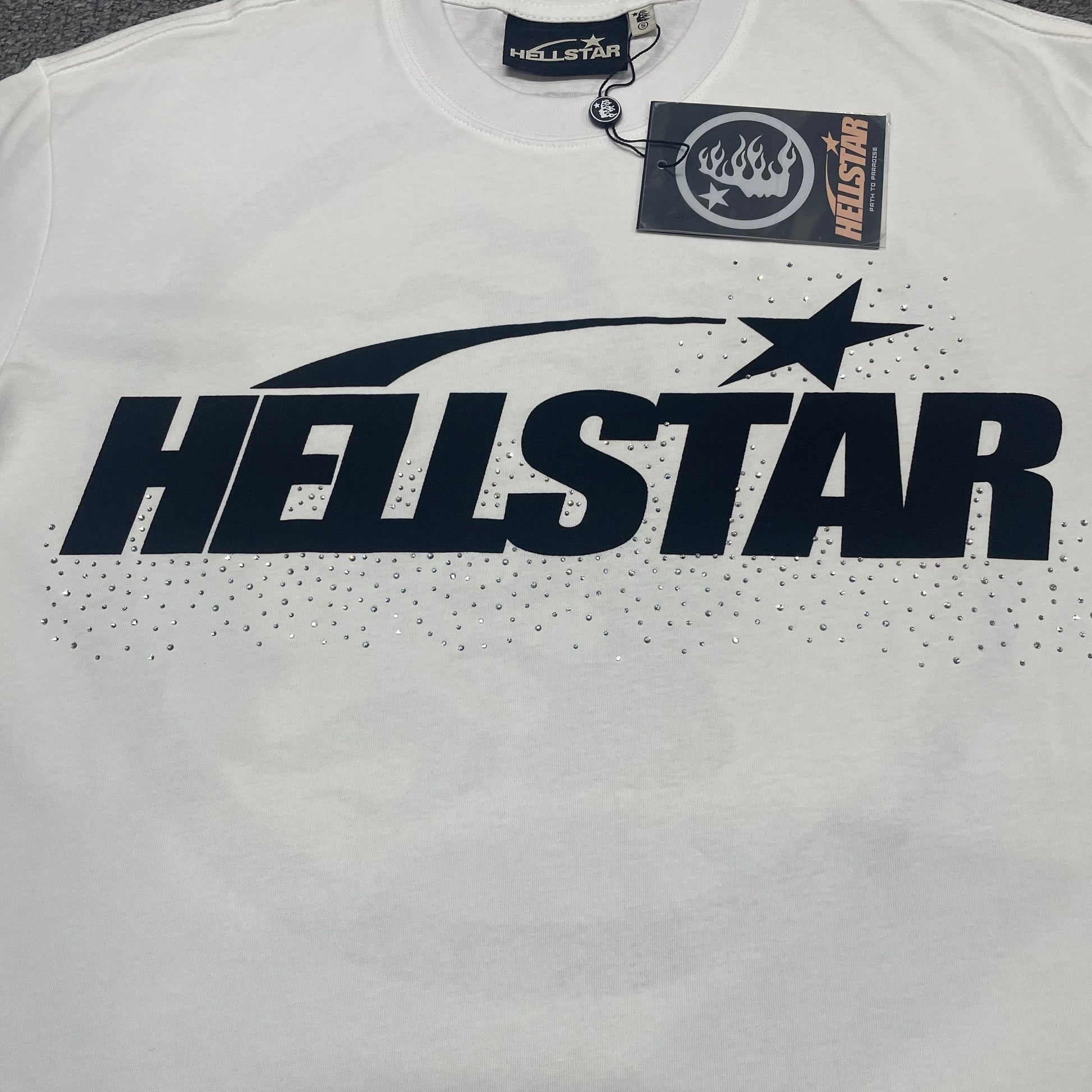 Full Hellstar Sports Core logo and rhinestone graphic on white T-shirt
Full rhinestone decoration surrounding the Hellstar Sports Core logo
Detailed rhinestone placement around the Hellstar logo graphic
Oversized Hellstar lettering detail on Sports Core white T-shirt
Shooting-star logo graphic detail on Hellstar Sports Core T-shirt