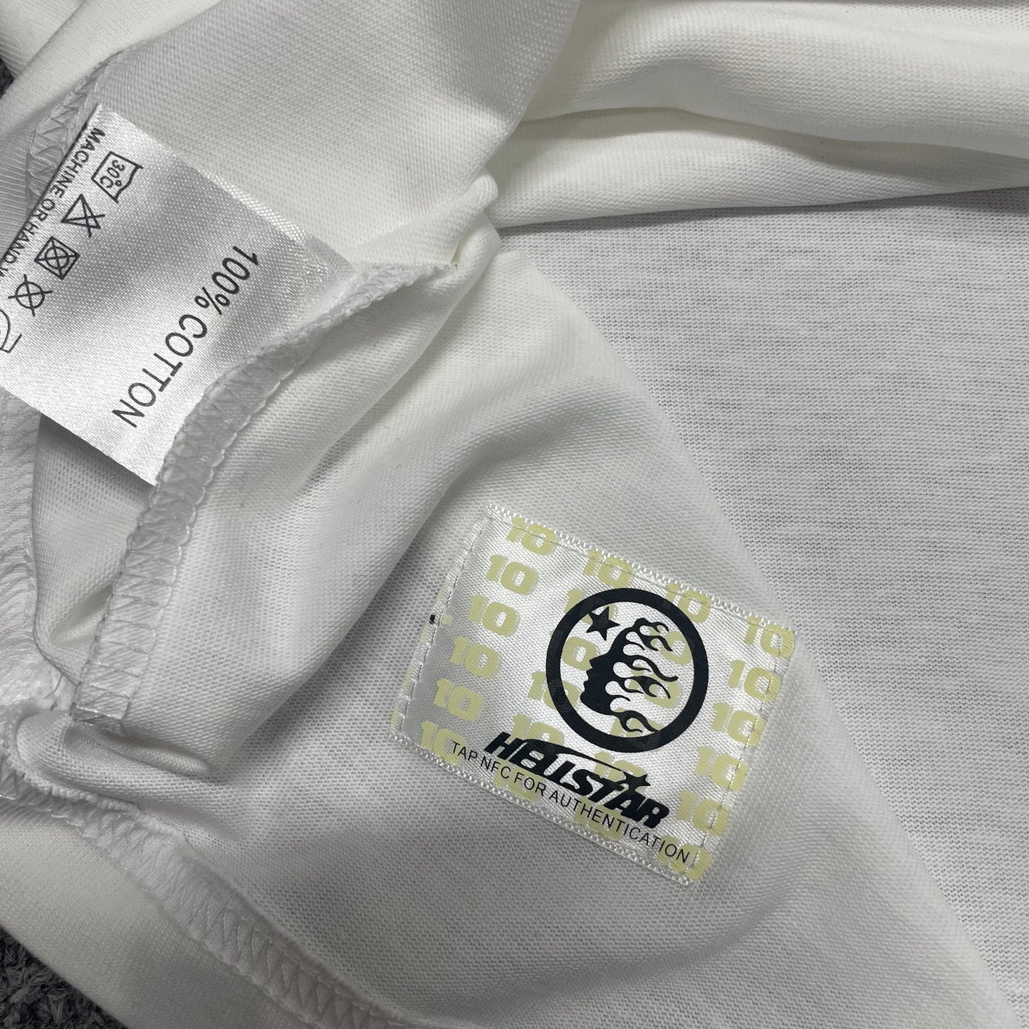 Hellstar wash care label inside Sports Core Rhinestone T-shirt
NFC tag detail attached to Hellstar Sports Core Rhinestone T-shirt