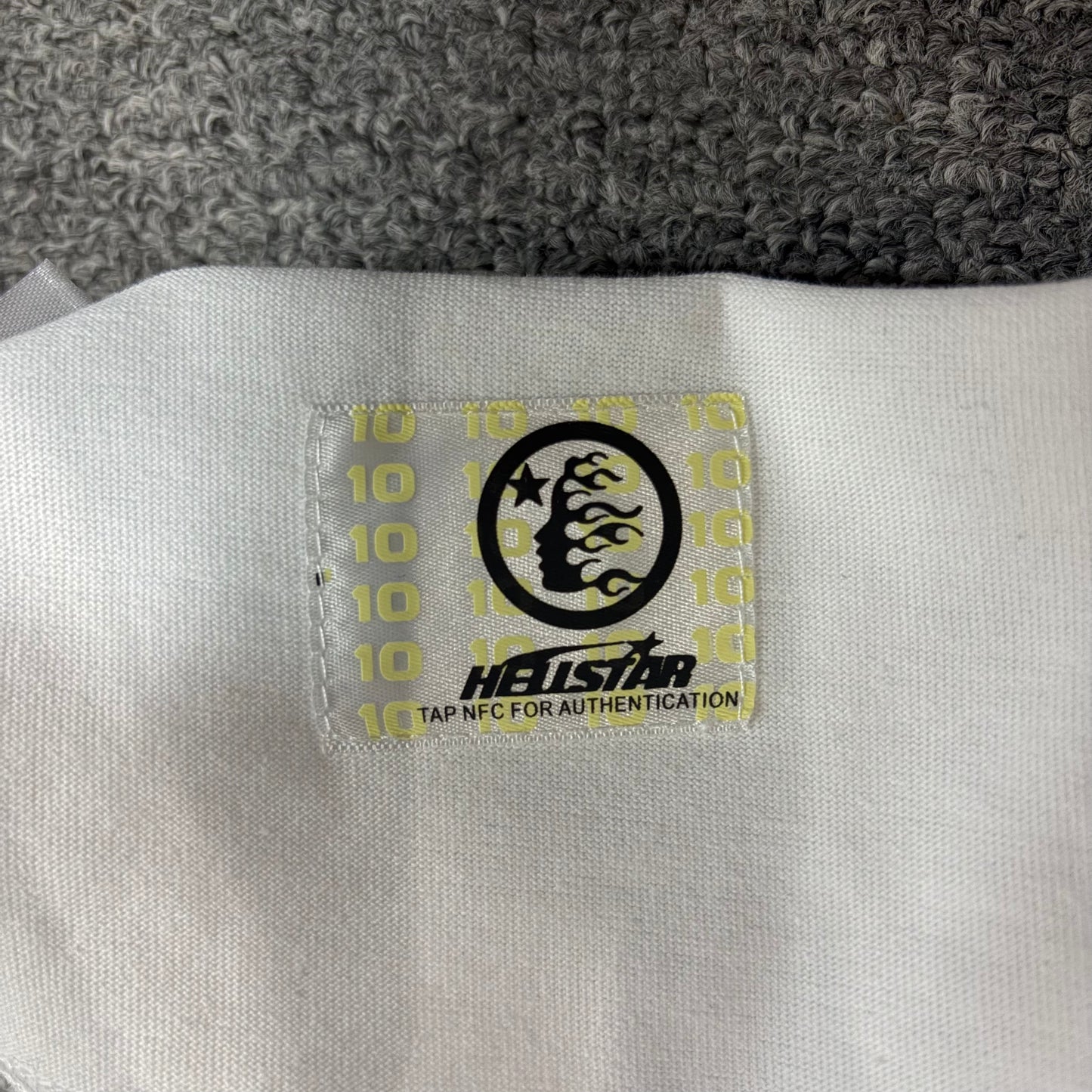 NFC tag detail attached to Hellstar Evil Eye white T-shirt