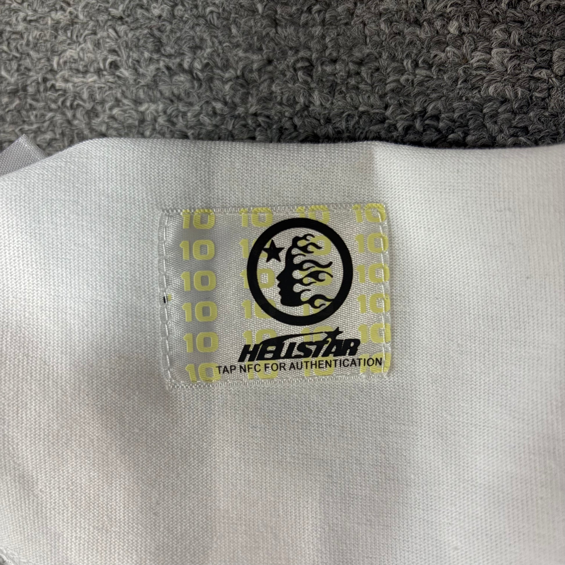 NFC tag detail attached to Hellstar Evil Eye white T-shirt