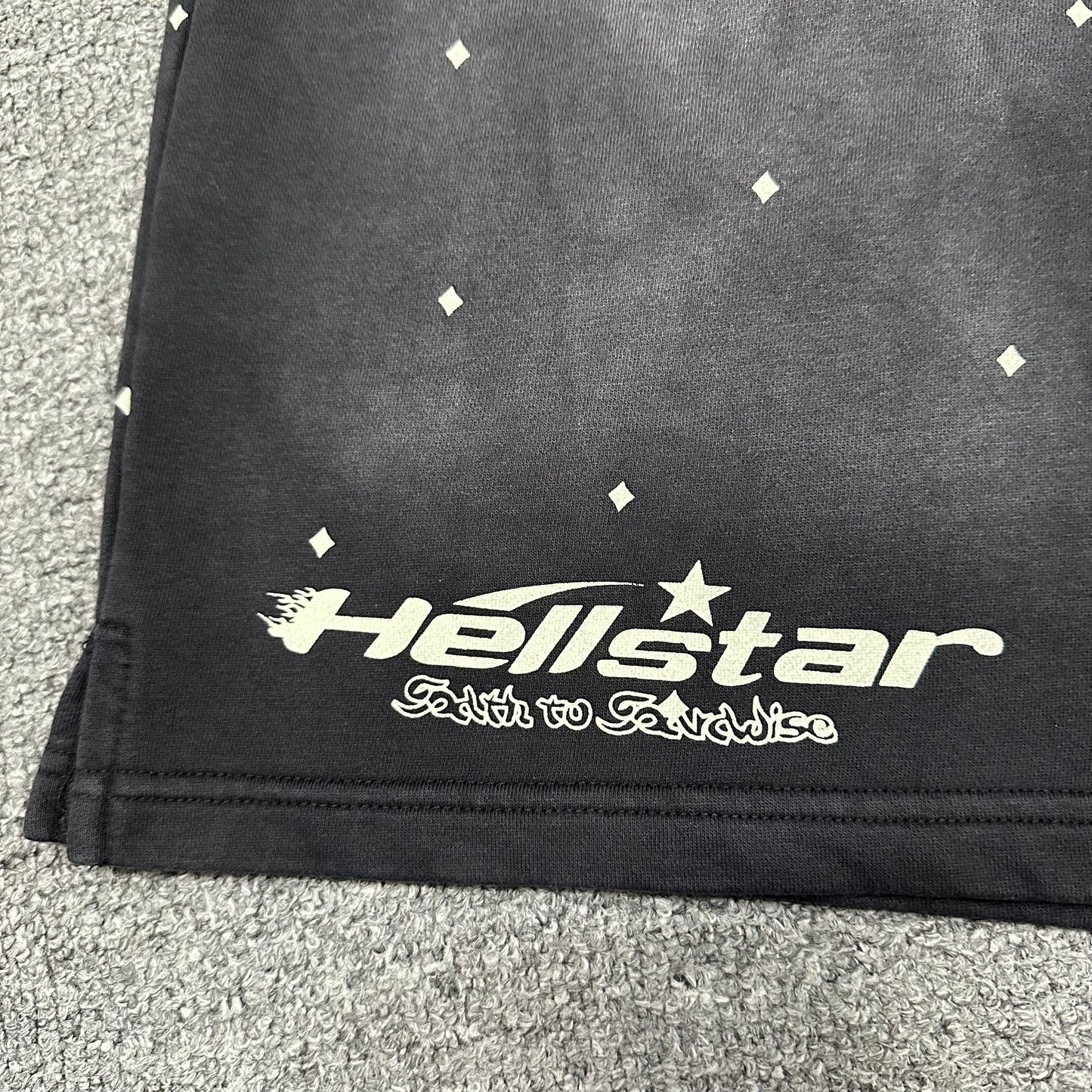 Full front graphic layout on Hellstar Path to Paradise washed black shorts
Close-up of Hellstar wordmark printed on the left leg of black shorts
