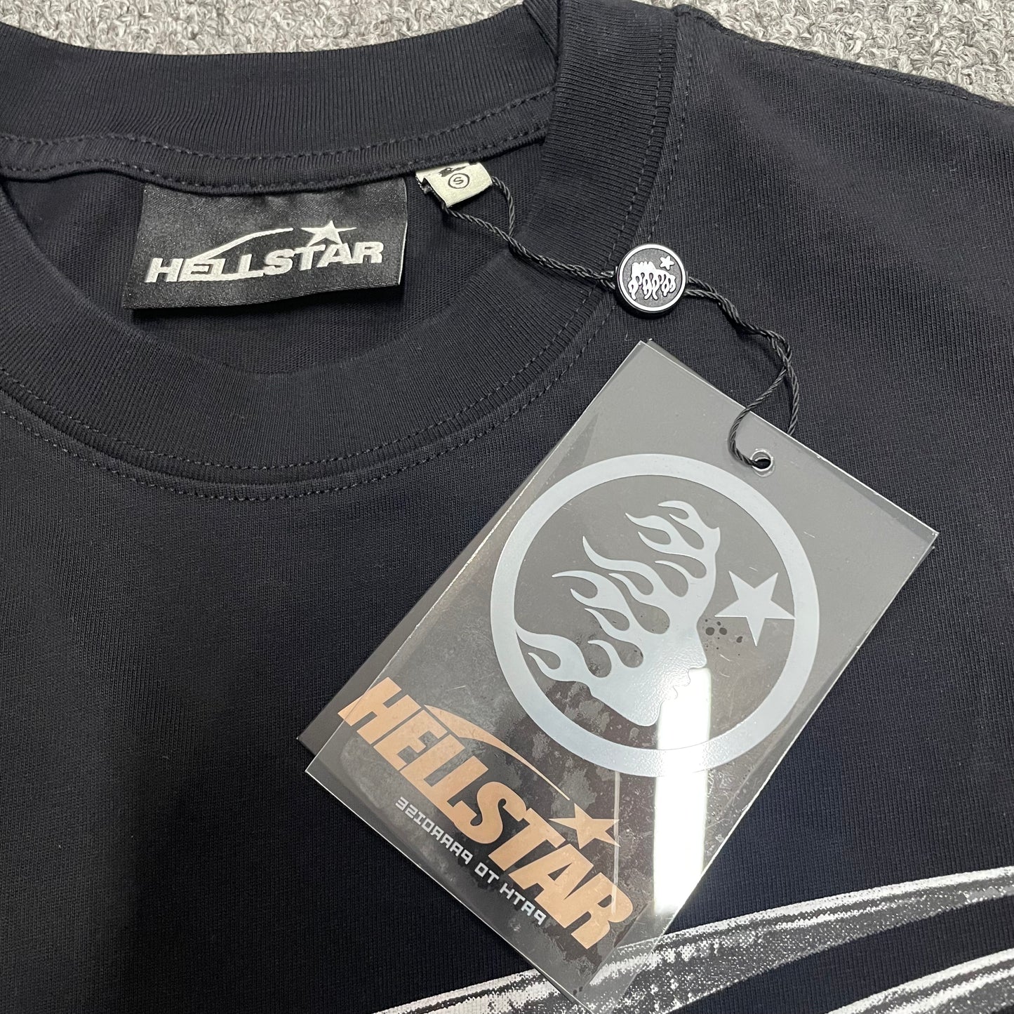 Crew neck collar and stitching detail on Hellstar Chrome Logo T-shirt
Crew neck collar and stitching detail on Hellstar Chrome Logo T-shirt
Hellstar size label detail inside Chrome Logo black T-shirt
Hellstar branded hangtag attached to Chrome Logo black T-shirt