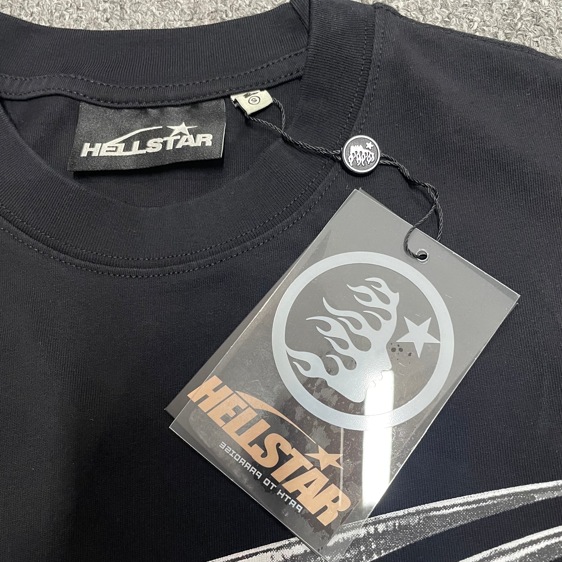 Crew neck collar and stitching detail on Hellstar Chrome Logo T-shirt
Crew neck collar and stitching detail on Hellstar Chrome Logo T-shirt
Hellstar size label detail inside Chrome Logo black T-shirt
Hellstar branded hangtag attached to Chrome Logo black T-shirt