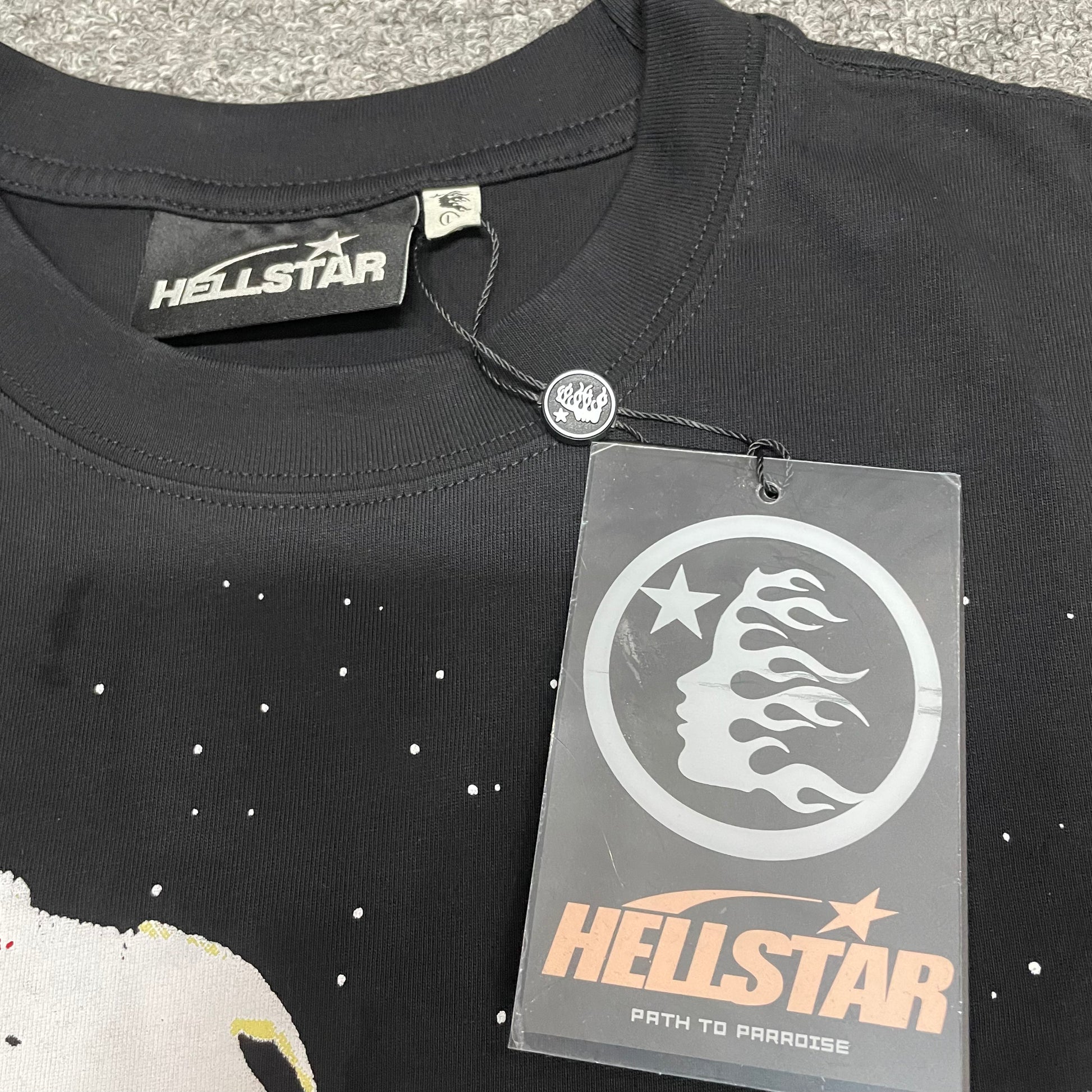 Crew neck collar and stitching detail on Hellstar UFO graphic T-shirt
Hellstar woven neck label inside UFO Attacks Planet black T-shirt
Hellstar branded hangtag attached to UFO Attacks Planet black T-shirt