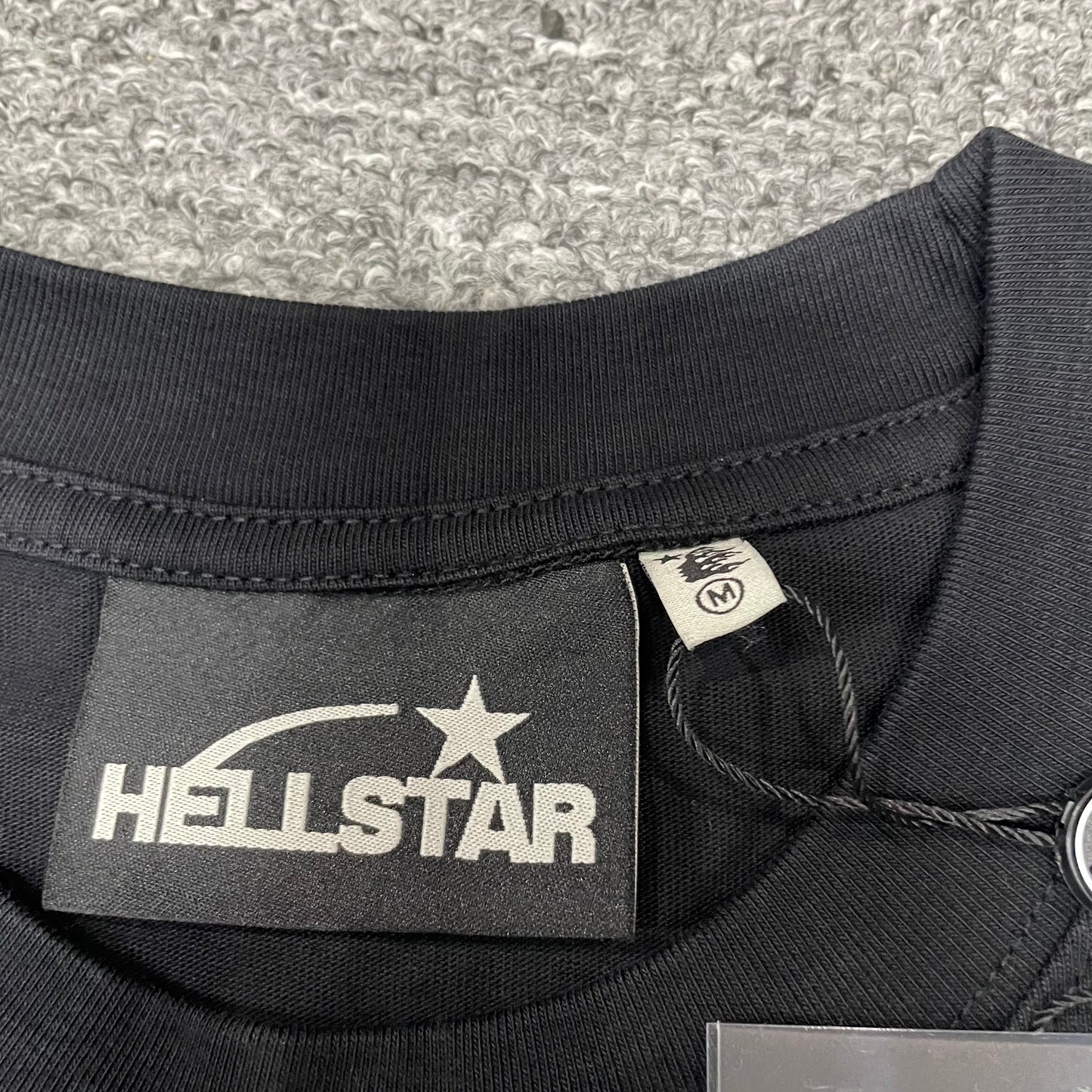 Crew neck collar and stitching detail on Hellstar Classic T-shirt
Hellstar woven neck label inside Classic washed black T-shirt
Hellstar size label detail inside Classic washed black T-shirt
Hellstar branded hangtag attached to Classic Logo black T-shirt