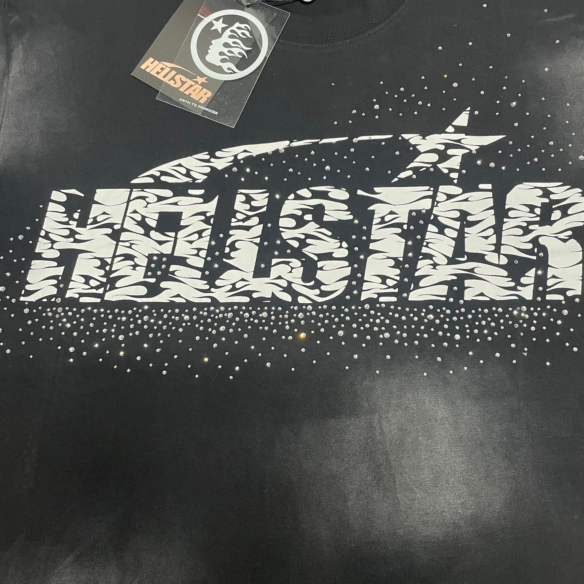 Full Hellstar rhinestone logo graphic on washed black T-shirt
Detailed view of reflective rhinestones and distressed Hellstar logo texture