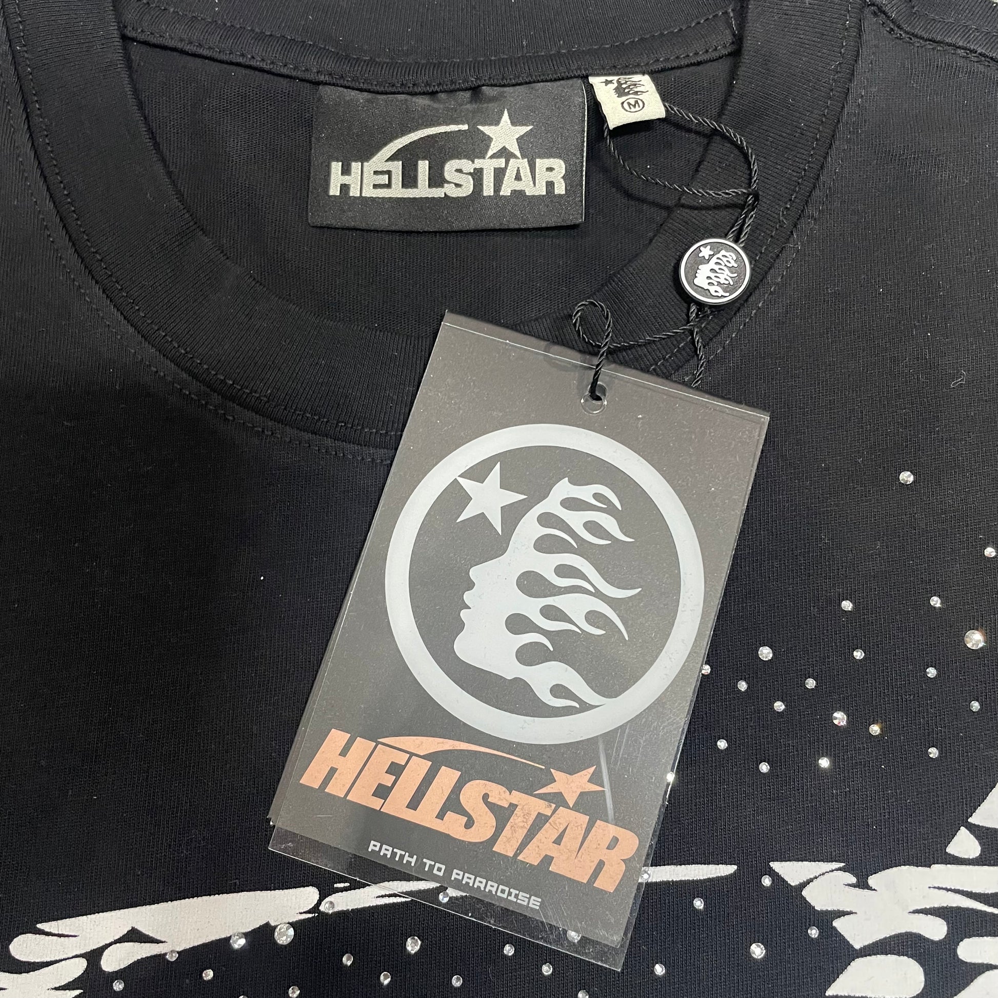 Hellstar neck label inside washed black rhinestone T-shirt
Hellstar branded hang tag attached to black rhinestone T-shirt