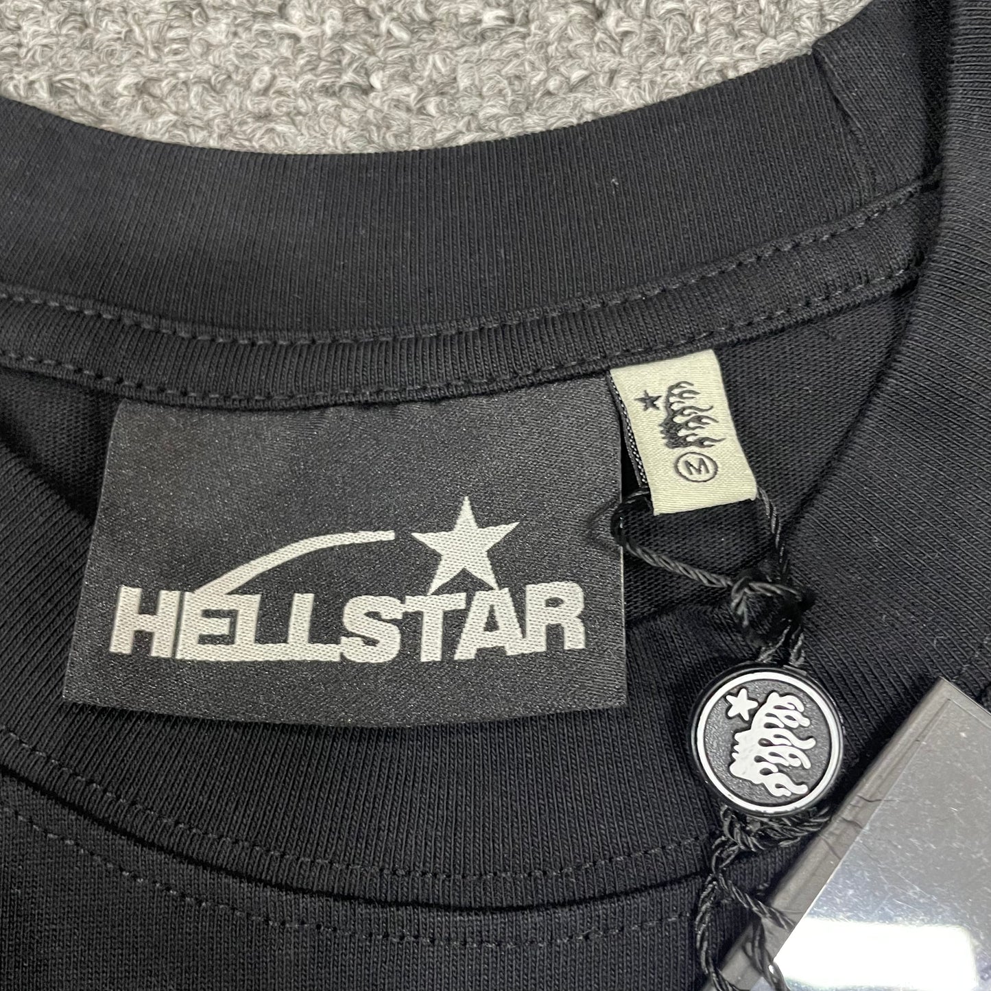 Close-up of ribbed crew neck and neckline stitching on Hellstar T-shirt
Hellstar neck label inside No Guts No Glory black T-shirt
Size label inside Hellstar No Guts No Glory T-shirt
Hellstar branded hang tag attached to green camo graphic T-shirt