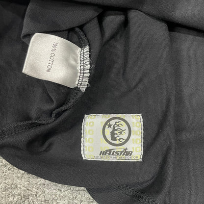 Close-up of bottom hem stitching on Hellstar washed black T-shirt
Fabric composition and care label inside Hellstar No Guts No Glory T-shirt
NFC tag detail on Hellstar No Guts No Glory camo T-shirt