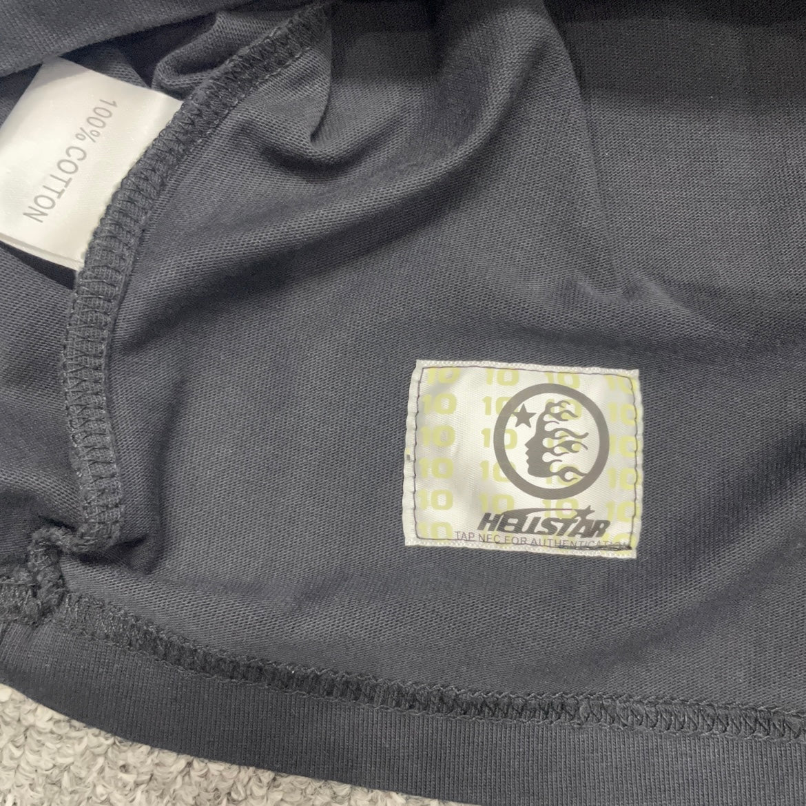Close-up of bottom hem stitching on Hellstar Glory Doll T-shirt
Fabric composition and care label inside Hellstar Glory Doll T-shirt
NFC tag detail on Hellstar Glory Doll washed black T-shirt