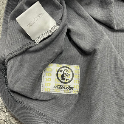 Close-up of bottom hem stitching on Hellstar washed grey T-shirt
Fabric composition and care label inside Hellstar Spray Paint Logo T-shirt
NFC tag detail on Hellstar Spray Paint Logo washed grey T-shirt