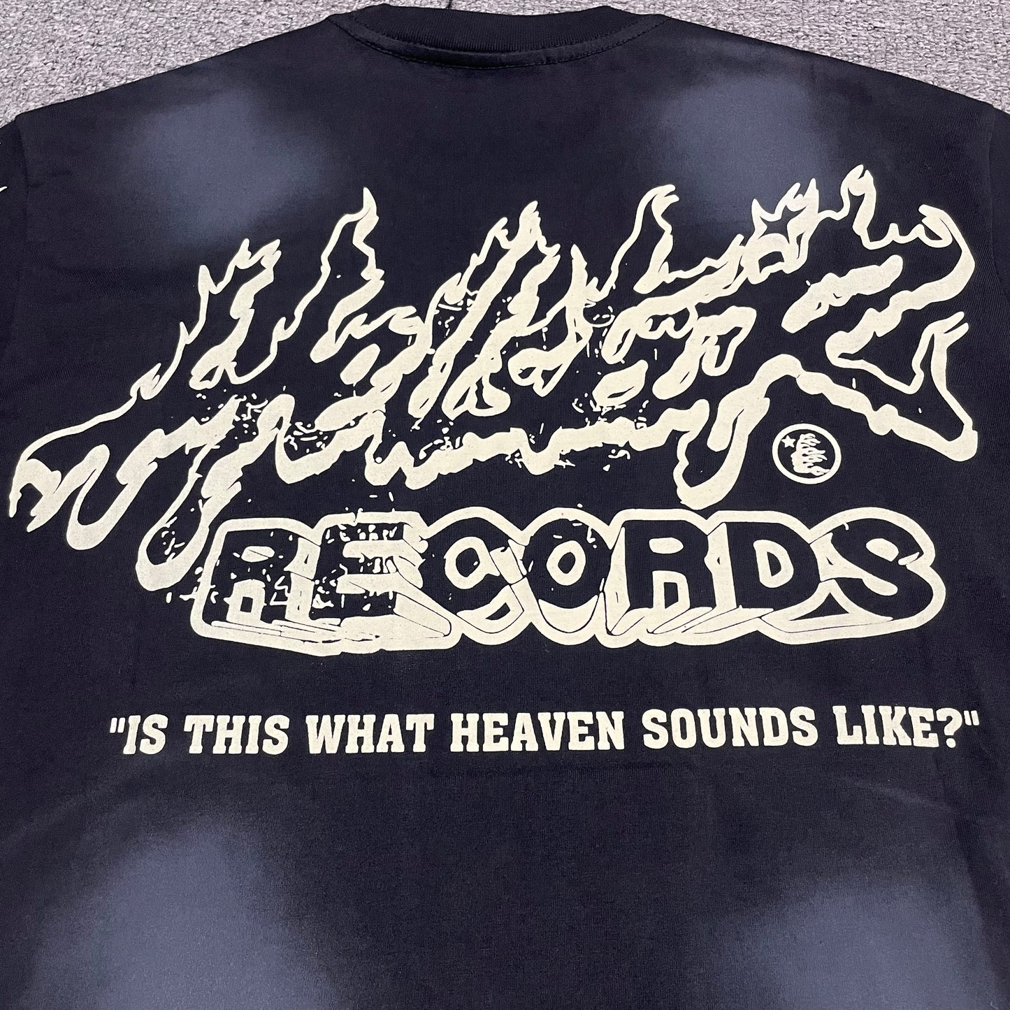 Full Hellstar Records back graphic on washed black T-shirt
Hellstar Records distressed cream graphic with flame and splatter details on black T-shirt
Close-up of Hellstar Records back print and heaven sounds like slogan
Is This What Heaven Sounds Like text detail on Hellstar Records T-shirt