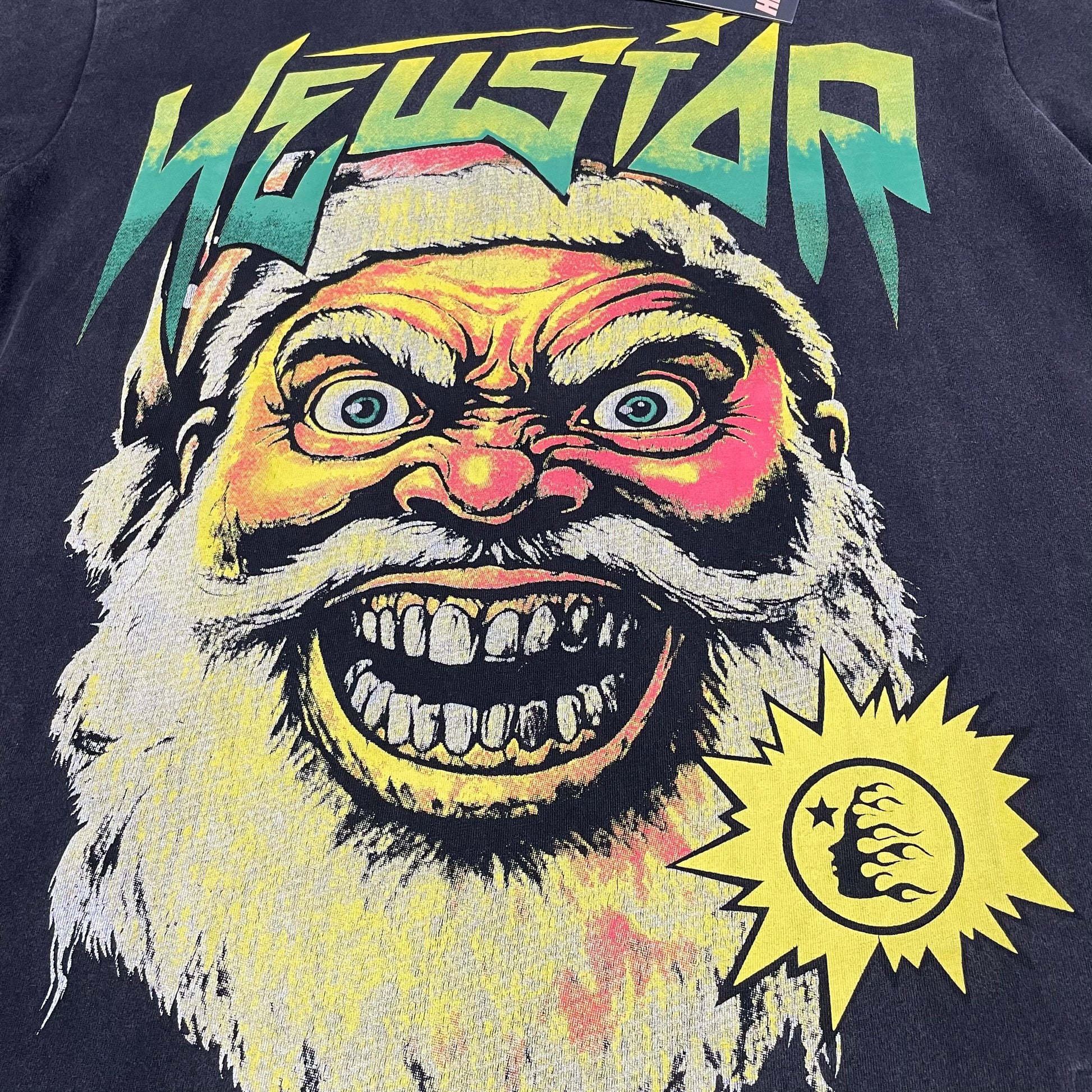 Oversized multicolor Santa face graphic on Hellstar washed black T-shirt
Hellstar Santa face artwork with yellow green red and cream distressed details
Gradient Hellstar logo above the oversized Santa face graphic
Close-up of oversized Santa face artwork on Hellstar black T-shirt
Detailed view of Santa eyes teeth beard and distressed graphic texture
