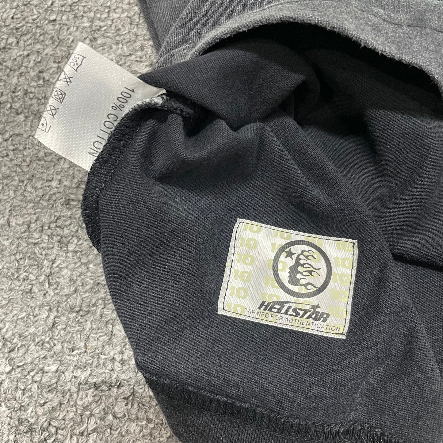 Close-up of bottom hem stitching on Hellstar washed black T-shirt
Fabric composition and care label inside Hellstar Santa Graphic T-shirt
NFC tag detail on Hellstar Santa Graphic washed black T-shirt