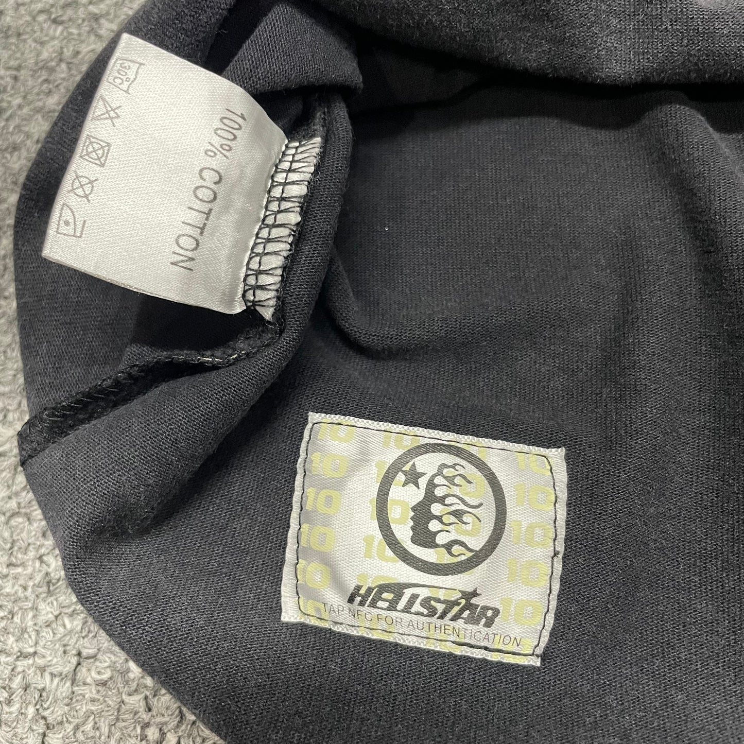 Close-up of bottom hem stitching on Hellstar Sports washed black T-shirt
Fabric composition and care label inside Hellstar Sports graphic T-shirt
NFC tag detail on Hellstar Sports mouth graphic T-shirt