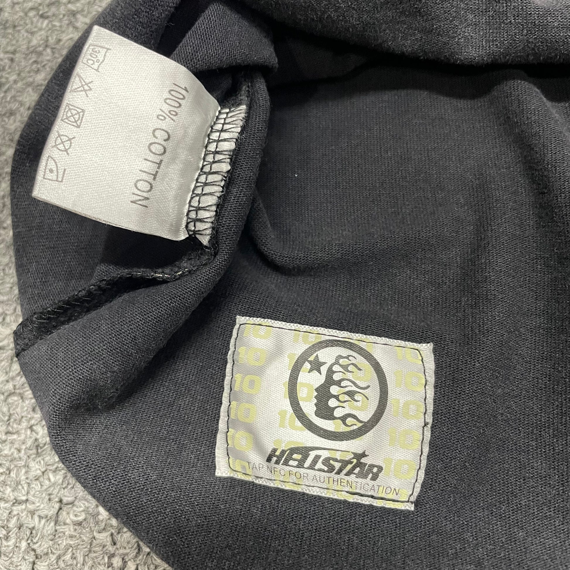 Close-up of bottom hem stitching on Hellstar Sports washed black T-shirt
Fabric composition and care label inside Hellstar Sports graphic T-shirt
NFC tag detail on Hellstar Sports mouth graphic T-shirt