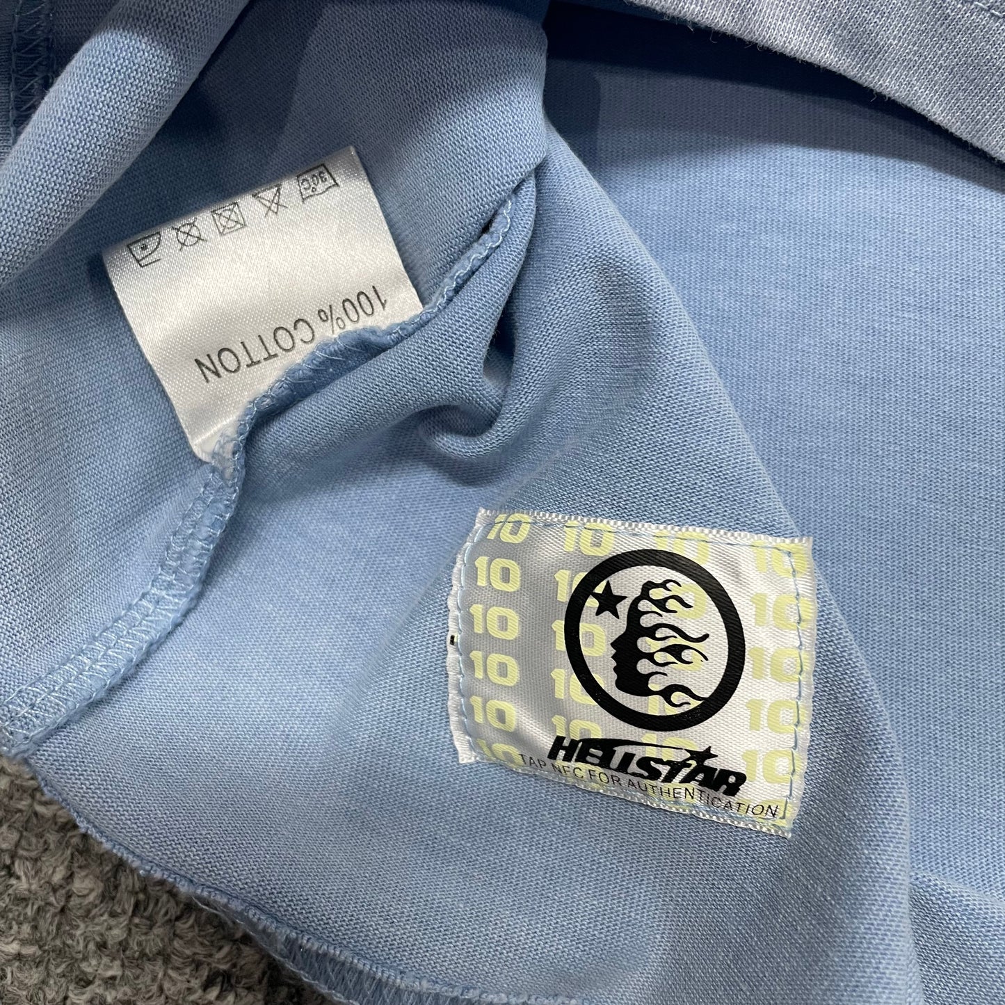 Close-up of straight bottom hem stitching on Hellstar Sports Core T-shirt
Fabric composition and care label inside Hellstar Sports Core T-shirt
NFC tag detail on Hellstar Sports Core rhinestone logo T-shirt