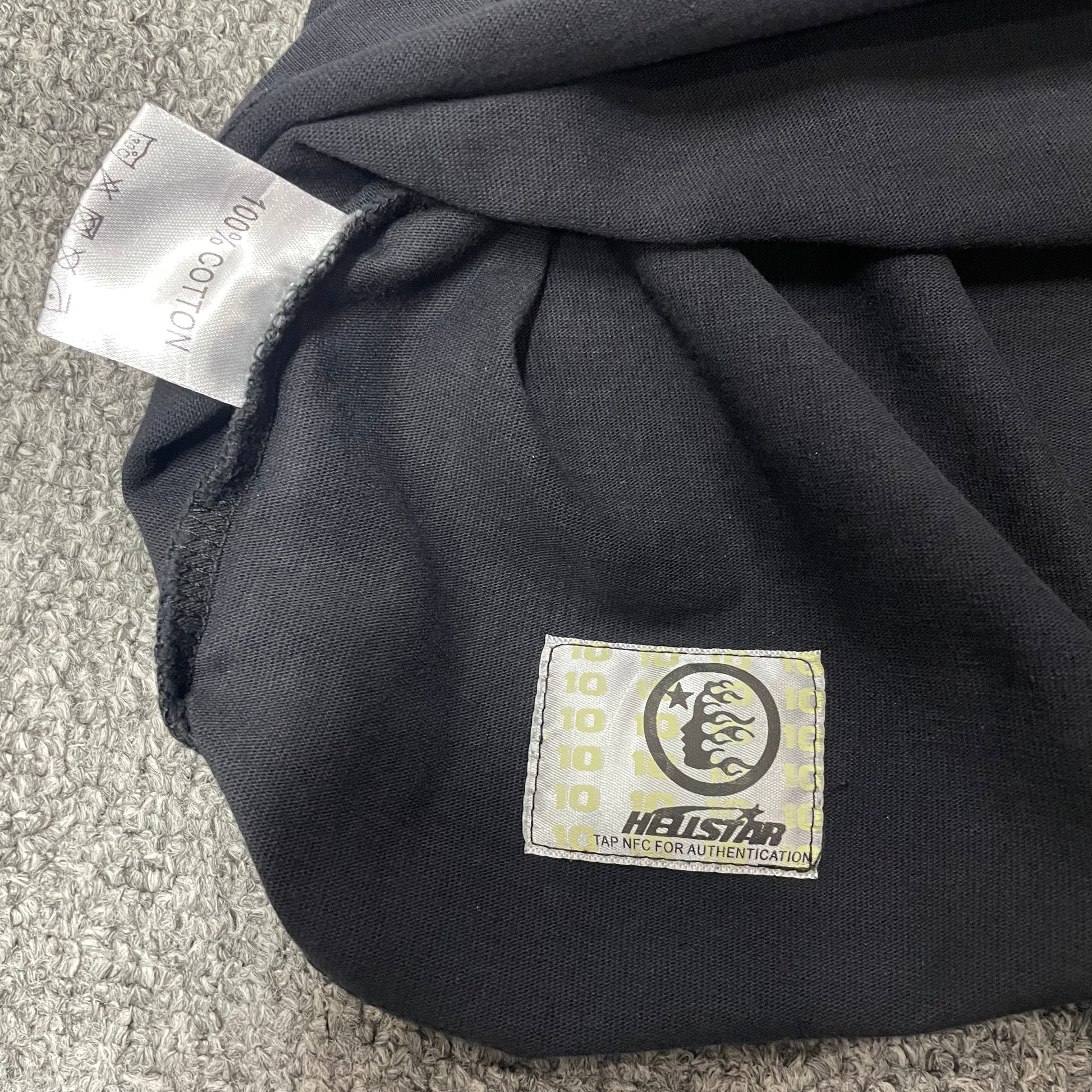 Close-up of bottom hem stitching on Hellstar Spiderweb T-shirt
Fabric composition and care label inside Hellstar Spiderweb Sport Logo T-shirt
NFC tag detail on Hellstar Spiderweb Sport Logo black T-shirt
