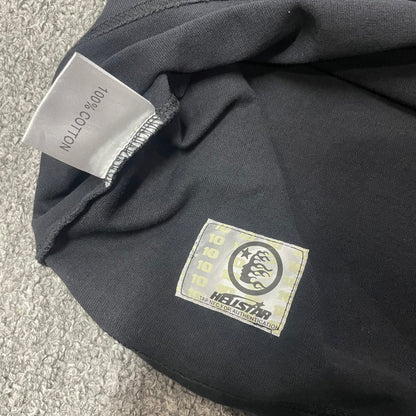 Close-up of bottom hem stitching on Hellstar Fist Bump T-shirt
Fabric composition and care label inside Hellstar Fist Bump T-shirt
NFC tag detail on Hellstar Fist Bump washed black T-shirt
