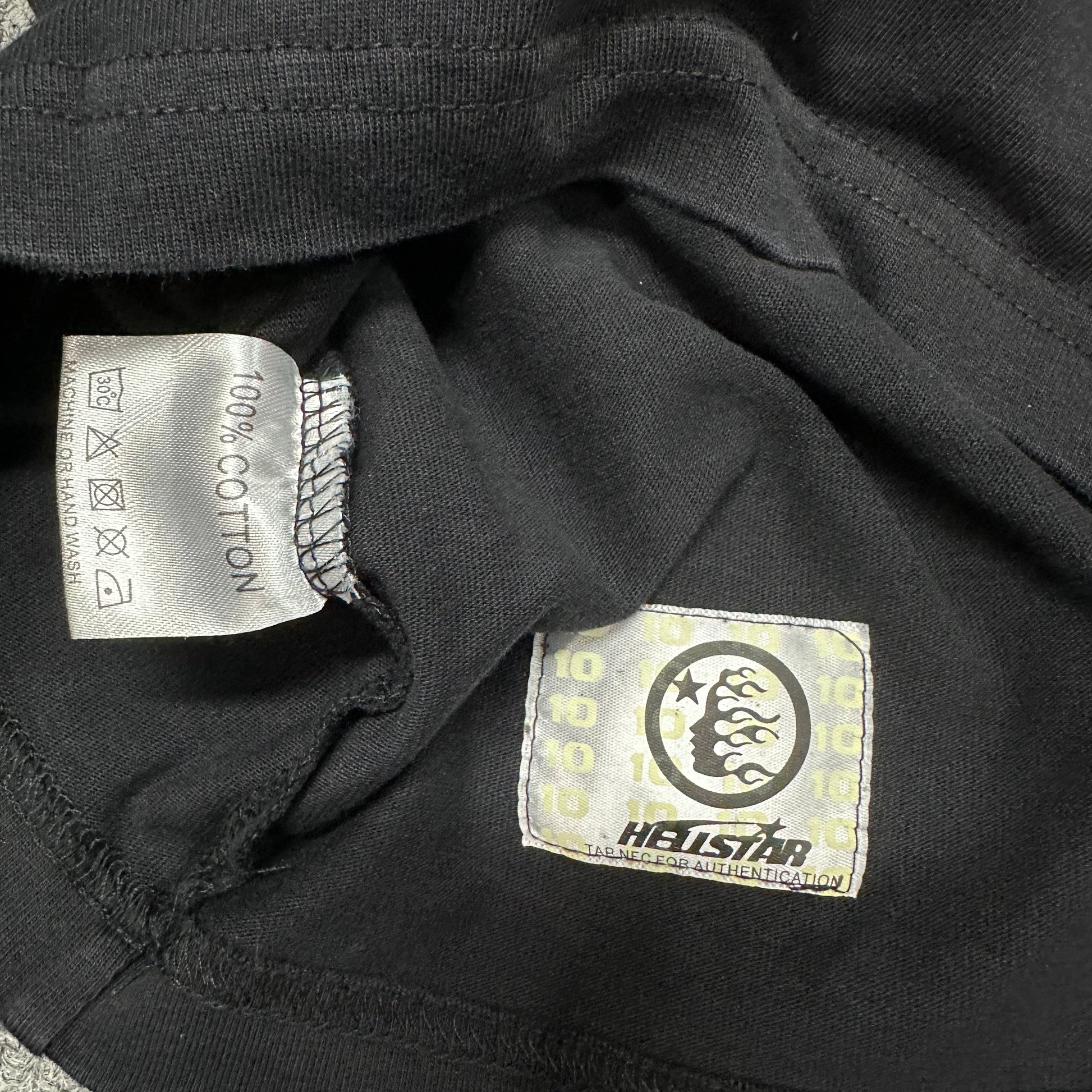 Close-up of bottom hem stitching on Hellstar Eyeball T-shirt
Fabric composition and care label inside Hellstar Eyeball T-shirt
NFC tag detail on Hellstar Eyeball washed black T-shirt