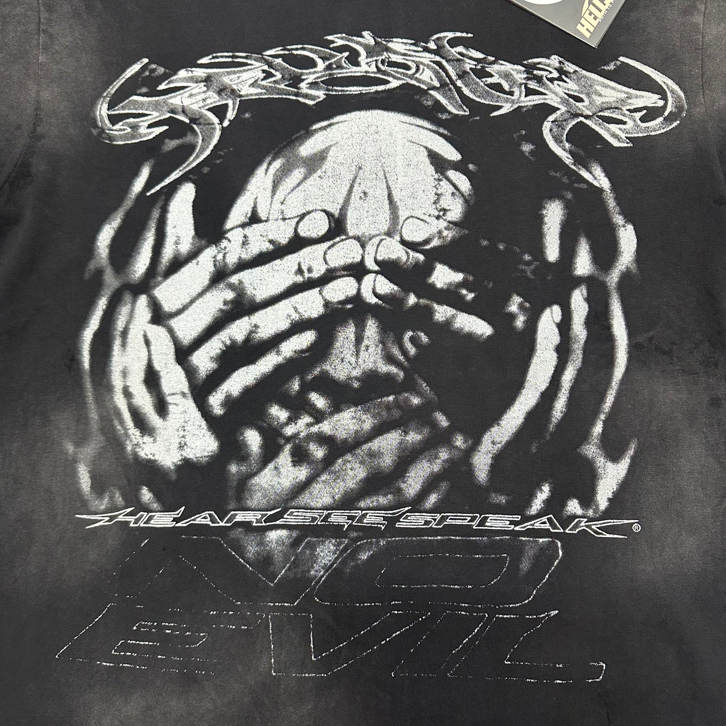 Oversized front No Evil face and hands graphic on Hellstar black T-shirt
Distressed monochrome artwork showing a face covered by layered hands
Close-up of Hellstar No Evil front graphic on washed black T-shirt
Close-up of monochrome face artwork on Hellstar No Evil T-shirt
Close-up of hands covering the eyes in Hellstar No Evil graphic
Detailed view of hands covering the ears in Hellstar No Evil artwork