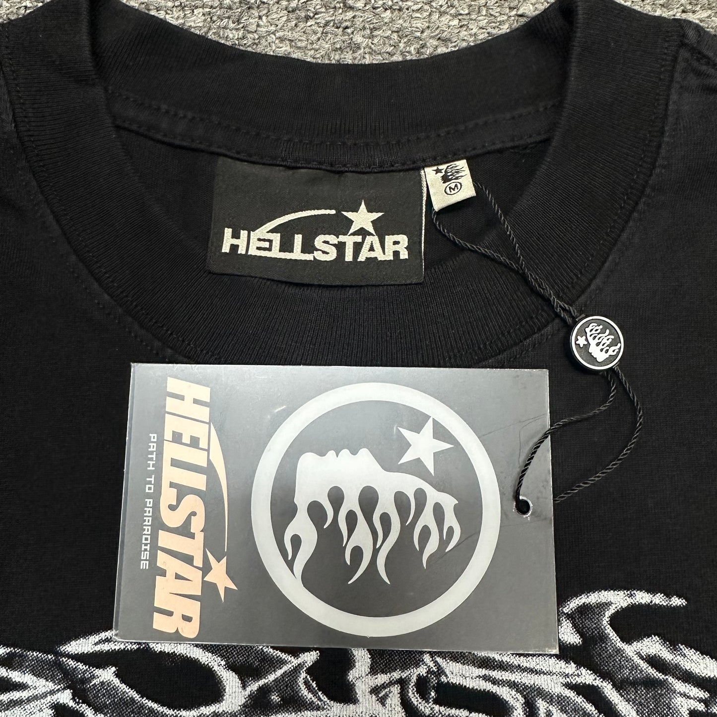Close-up of ribbed crew neck and neckline stitching on Hellstar No Evil T-shirt
Hellstar branded neck label inside No Evil graphic T-shirt
Size label inside Hellstar No Evil washed black T-shirt
Hellstar branded hang tag attached to No Evil graphic T-shirt