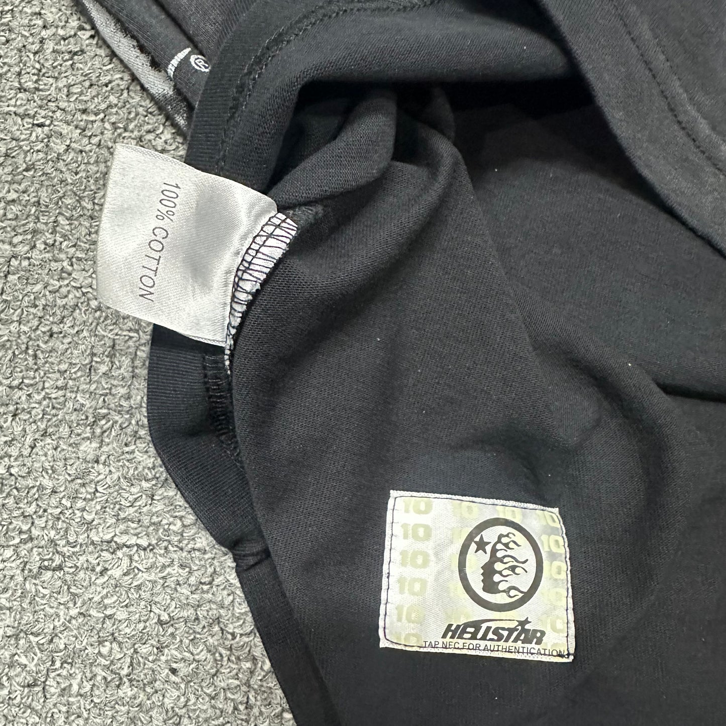 Close-up of bottom hem stitching on Hellstar No Evil T-shirt
Fabric composition and care label inside Hellstar No Evil T-shirt
NFC tag detail on Hellstar No Evil washed black T-shirt
