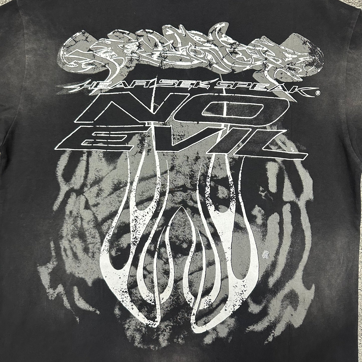 Oversized No Evil lettering and flame graphic on the back of Hellstar T-shirt
Hellstar Hear It Speak and No Evil typography with flame artwork
Close-up of No Evil back lettering and distressed graphic details
Close-up of distressed flame graphics on the back of Hellstar T-shirt
Vintage washed black finish and faded areas on Hellstar No Evil T-shirt