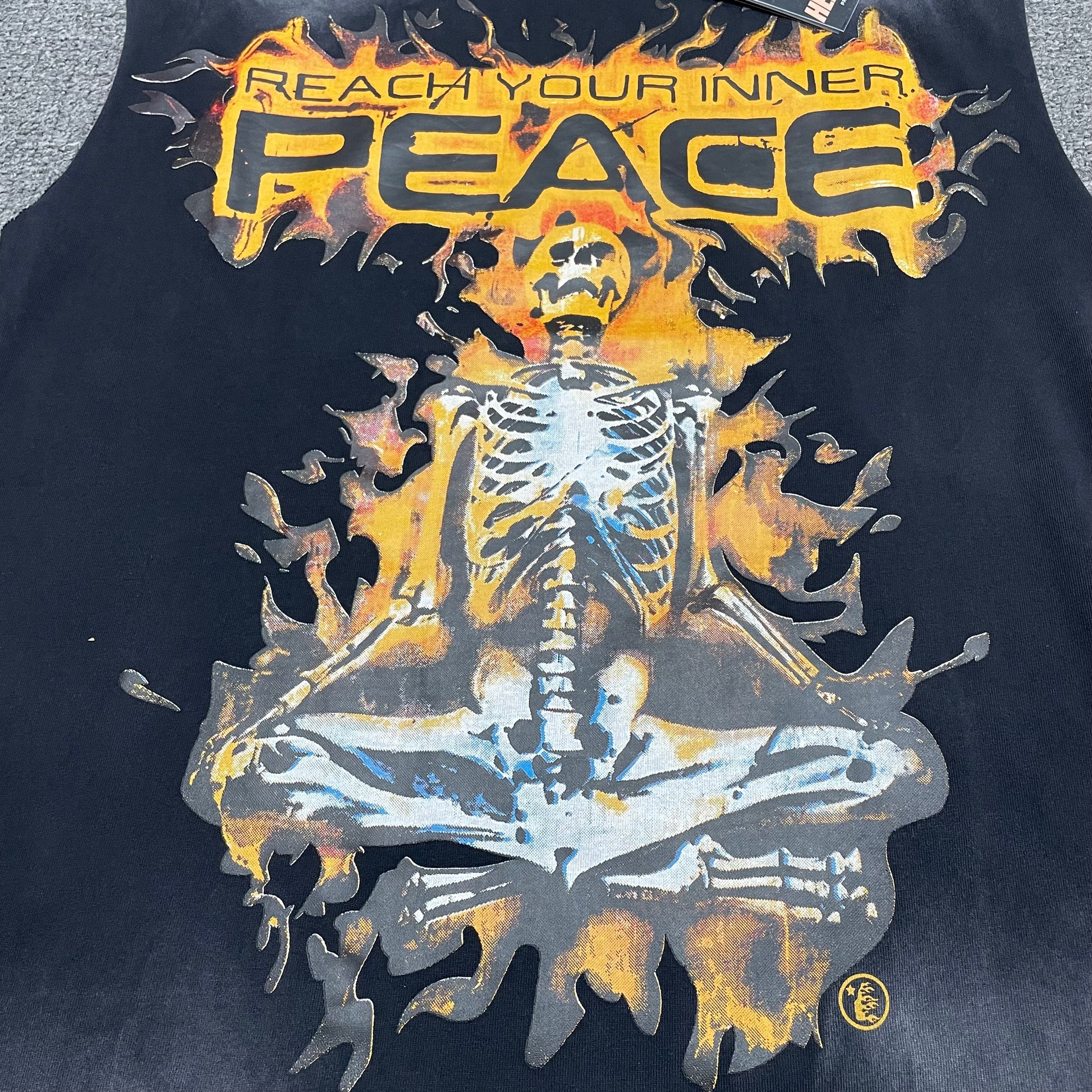 Full meditating skeleton graphic on Hellstar Inner Peace washed black sleeveless T-shirt
Reach Your Inner Peace text with meditating skeleton and flame artwork
Close-up of Hellstar meditating skeleton graphic on washed black sleeveless T-shirt