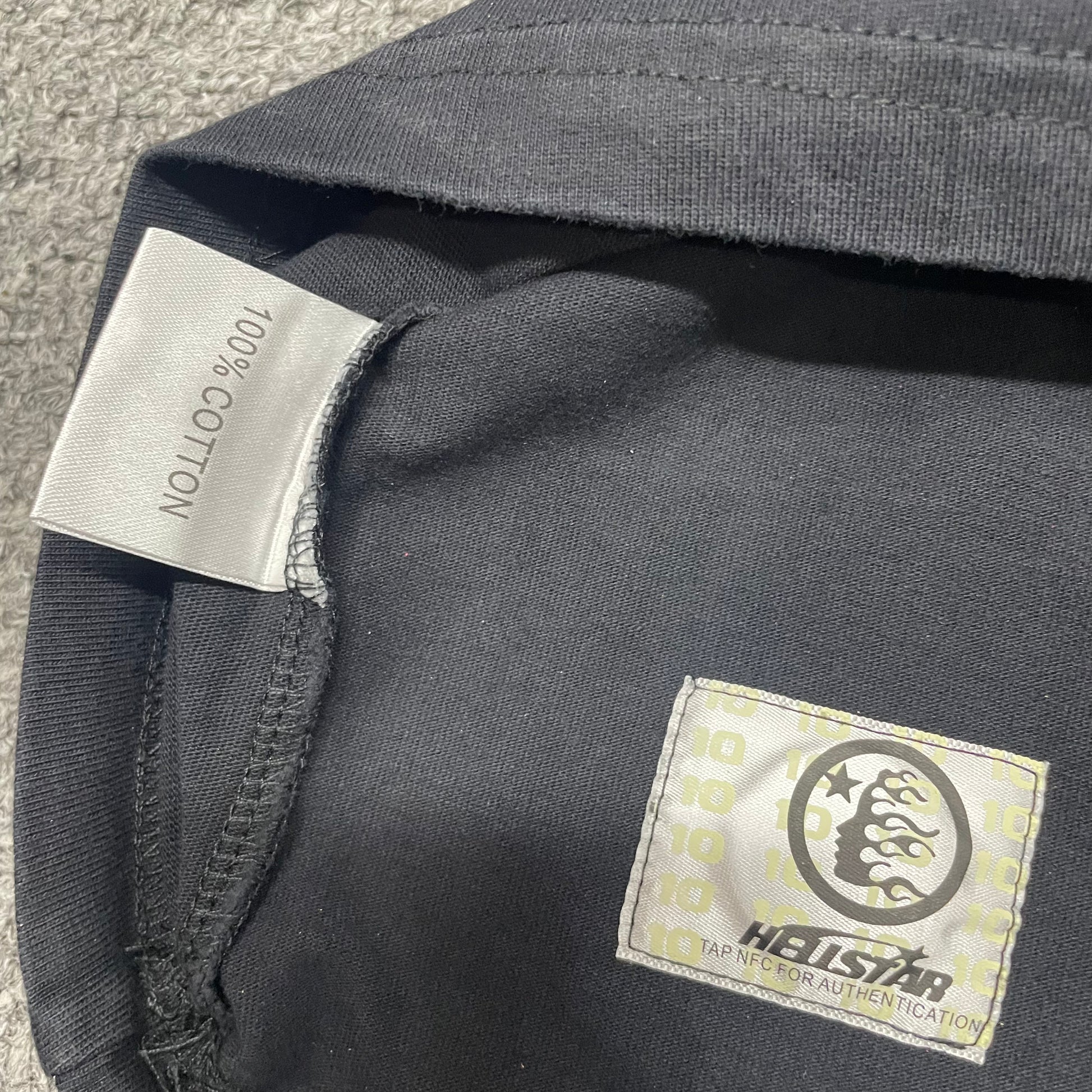 Close-up of bottom hem stitching on Hellstar Worship Hands T-shirt
Fabric composition and care label inside Hellstar Worship Hands sleeveless T-shirt
NFC tag detail on Hellstar Worship Hands washed black T-shirt