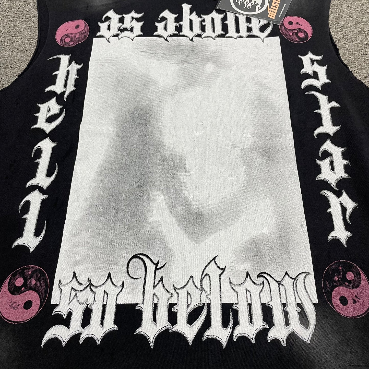 Full As Above So Below gothic graphic on Hellstar washed black cutoff T-shirt
Gothic As Above So Below lettering with yin-yang symbols and faded central artwork
Close-up of As Above So Below front graphic on Hellstar black T-shirt
Close-up of gothic As Above lettering on Hellstar sleeveless T-shirt