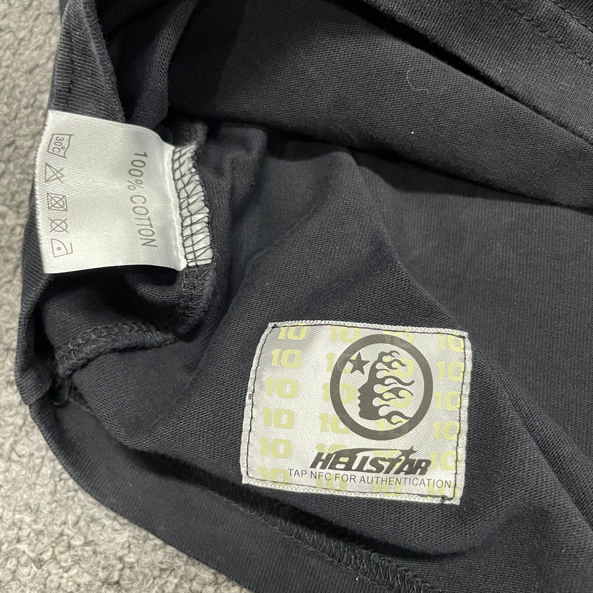 Close-up of bottom hem stitching on Hellstar cutoff T-shirt
Fabric composition and care label inside Hellstar As Above So Below T-shirt
NFC tag detail on Hellstar As Above So Below cutoff T-shirt