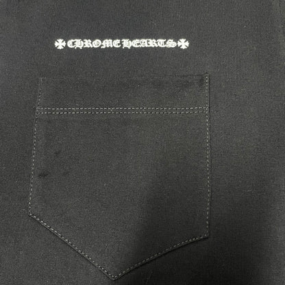 Chrome Hearts white logo print above the chest pocket on black T-shirt
Close-up of white Chrome Hearts lettering and front chest pocket print detail
