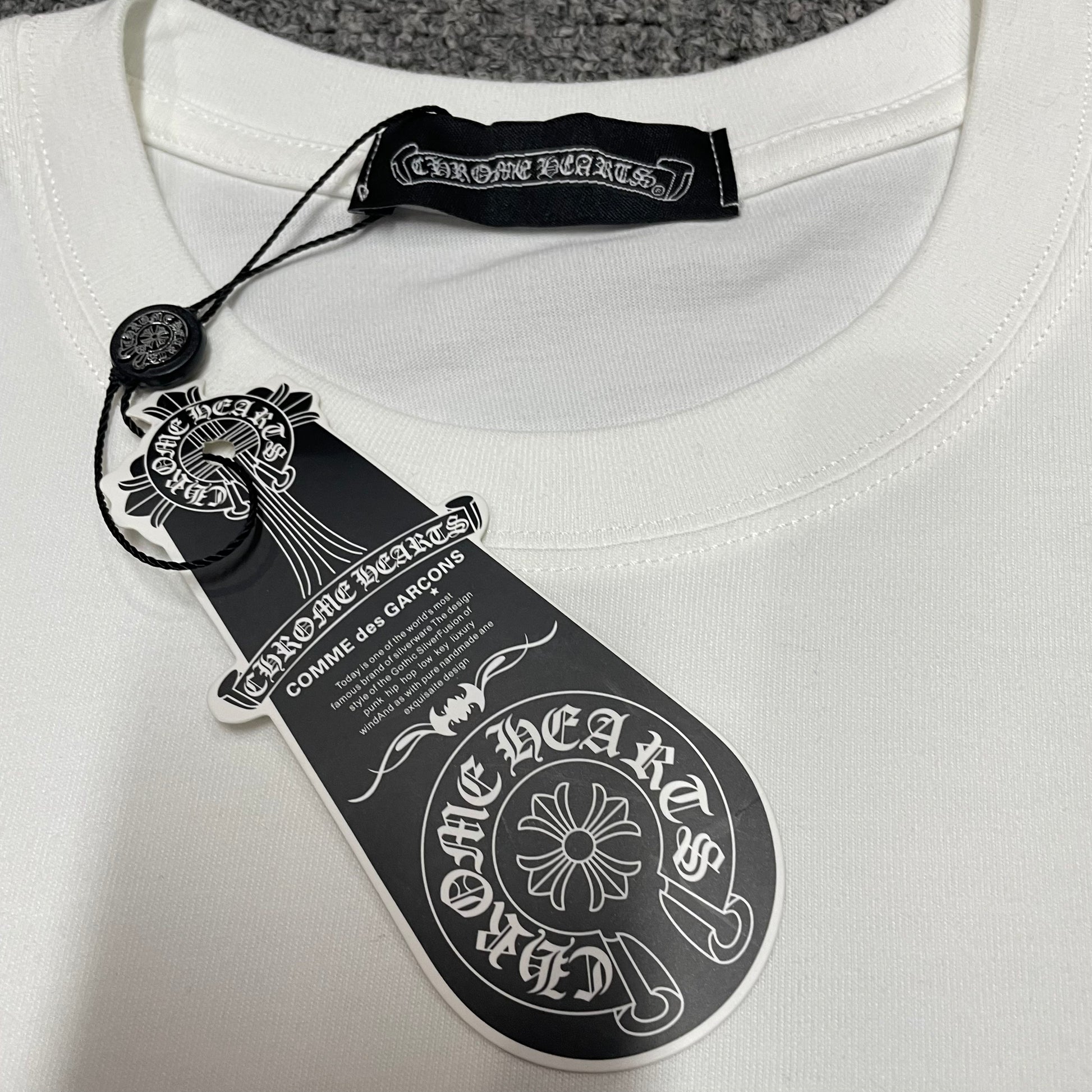 Chrome Hearts style t-shirt collar label hang tag and neck detail
Chrome Hearts style t-shirt size label wash label and hem stitching detail
