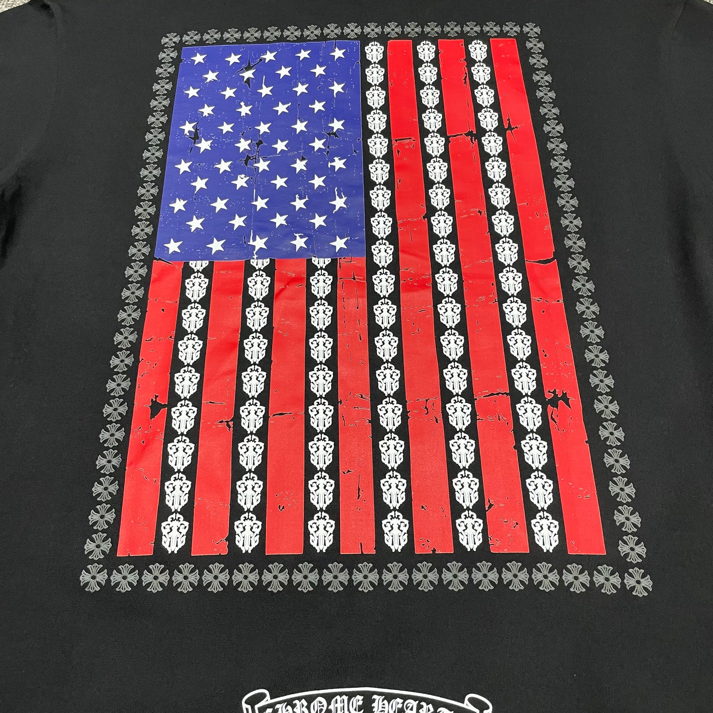 Oversized distressed American flag and dagger graphic on the back of Chrome Hearts T-shirt
Close-up of distressed American flag print with repeating dagger and cross motifs
Back graphic guide showing the distressed American flag and repeating dagger design