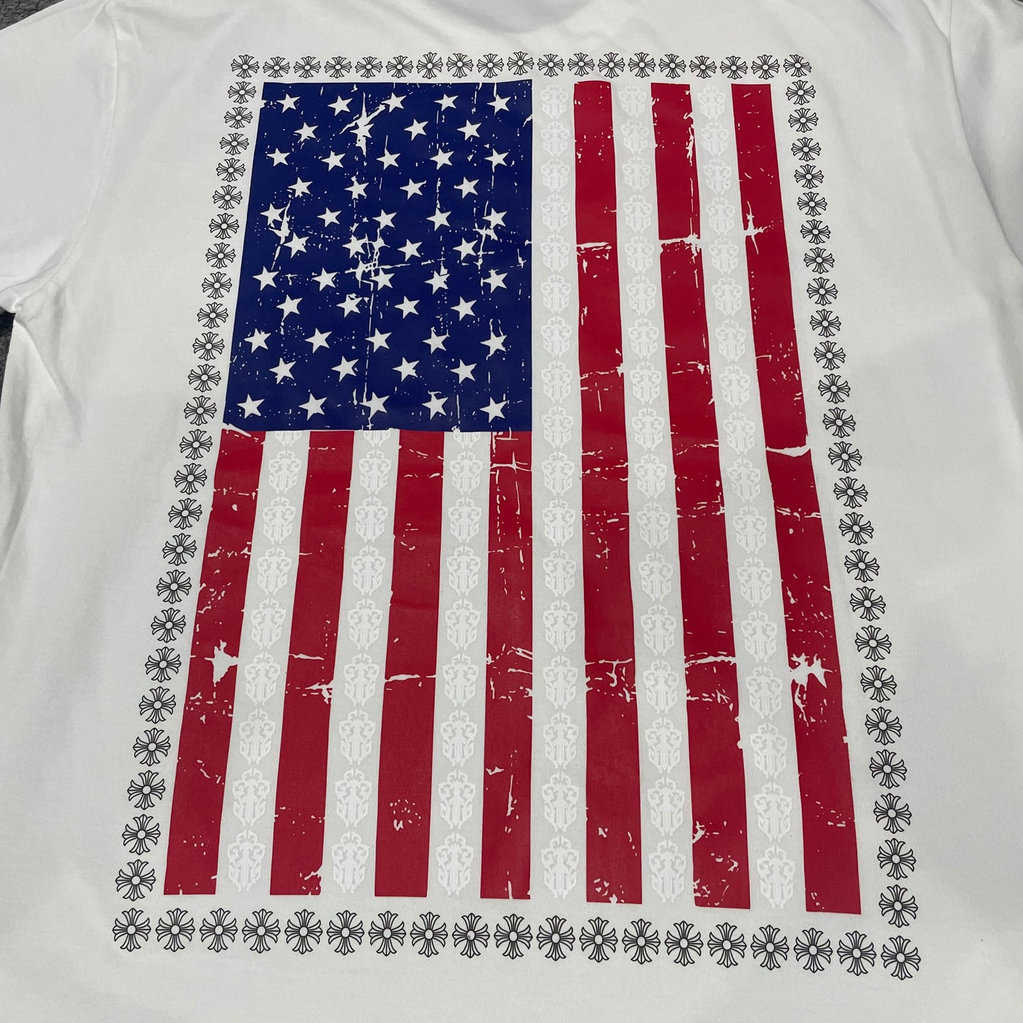 Oversized distressed American flag and dagger graphic on the back of Chrome Hearts T-shirt
Close-up of distressed American flag print with repeating dagger and cross motifs
Back graphic guide showing the distressed American flag and repeating dagger design
