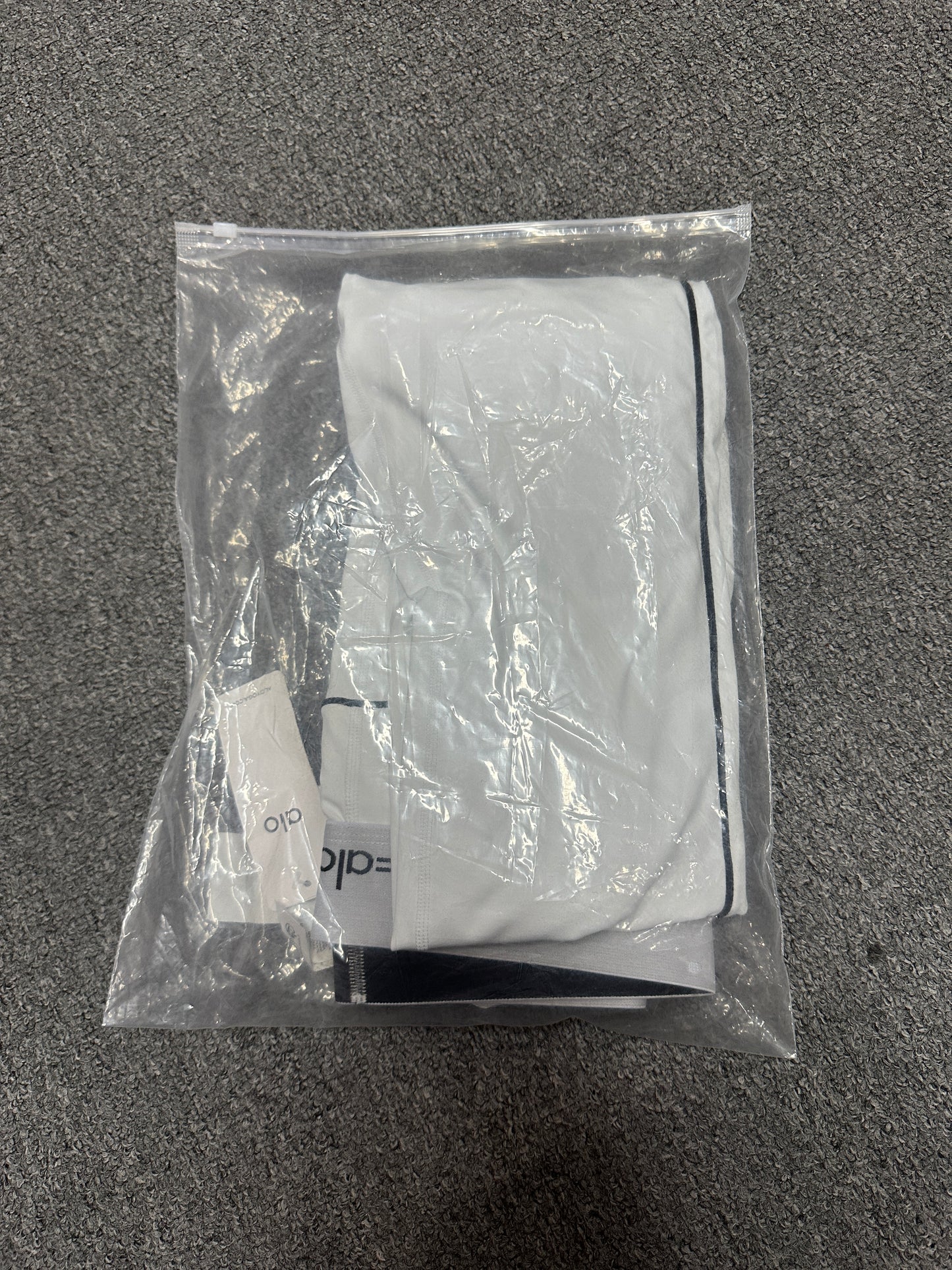 ALO Heart Throb White Black bra and legging set inside branded packaging bag