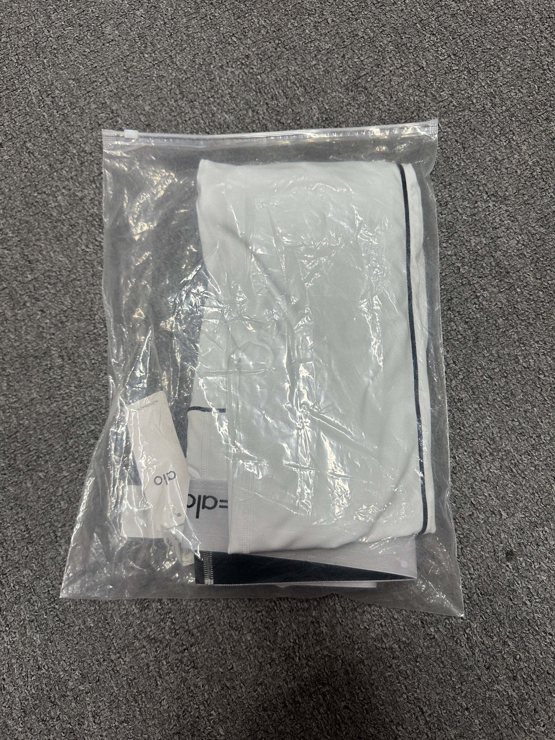 ALO Heart Throb White Black bra and legging set inside branded packaging bag
