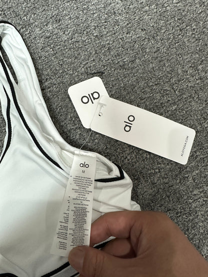 ALO Heart Throb White Black bra scoop neckline and contrast piping detail
ALO Heart Throb White Black sports bra shoulder strap stitching detail
ALO Heart Throb White Black sports bra inner label and size detail
ALO Heart Throb White Black activewear set with branded retail hangtags
ALO Heart Throb White Black workout set care label and fabric information