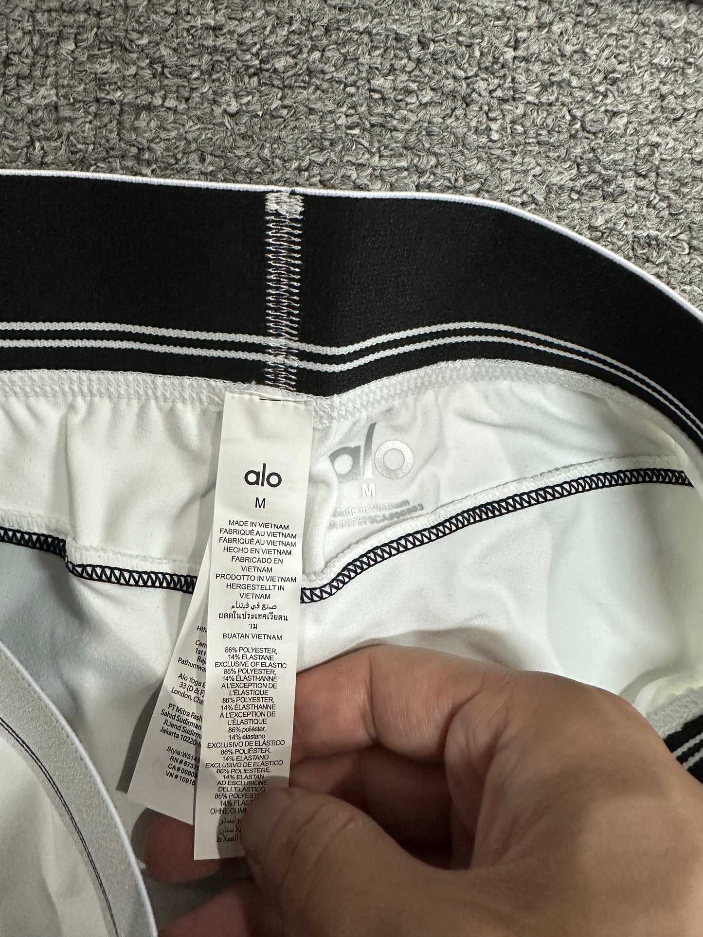 ALO Heart Throb White Black legging elastic logo waistband construction detail
ALO Heart Throb White Black workout set care label and fabric information
ALO Heart Throb White Black high-waist legging inner label and size detail
White Black ALO Heart Throb stretch fabric inner surface close-up