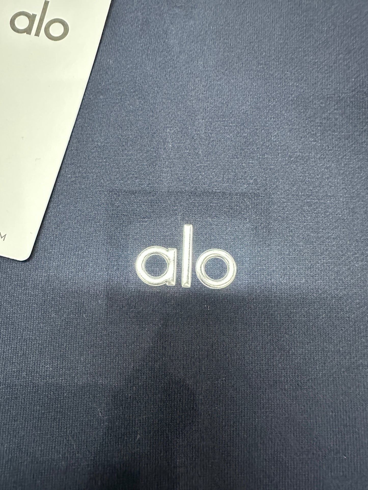 Embroidered ALO chest logo close-up on Navy Accolade quarter zip pullover
