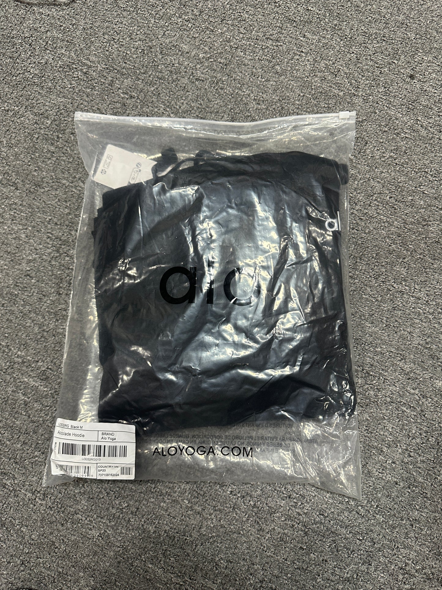 Embroidered ALO chest logo close-up on Black Accolade Hoodie