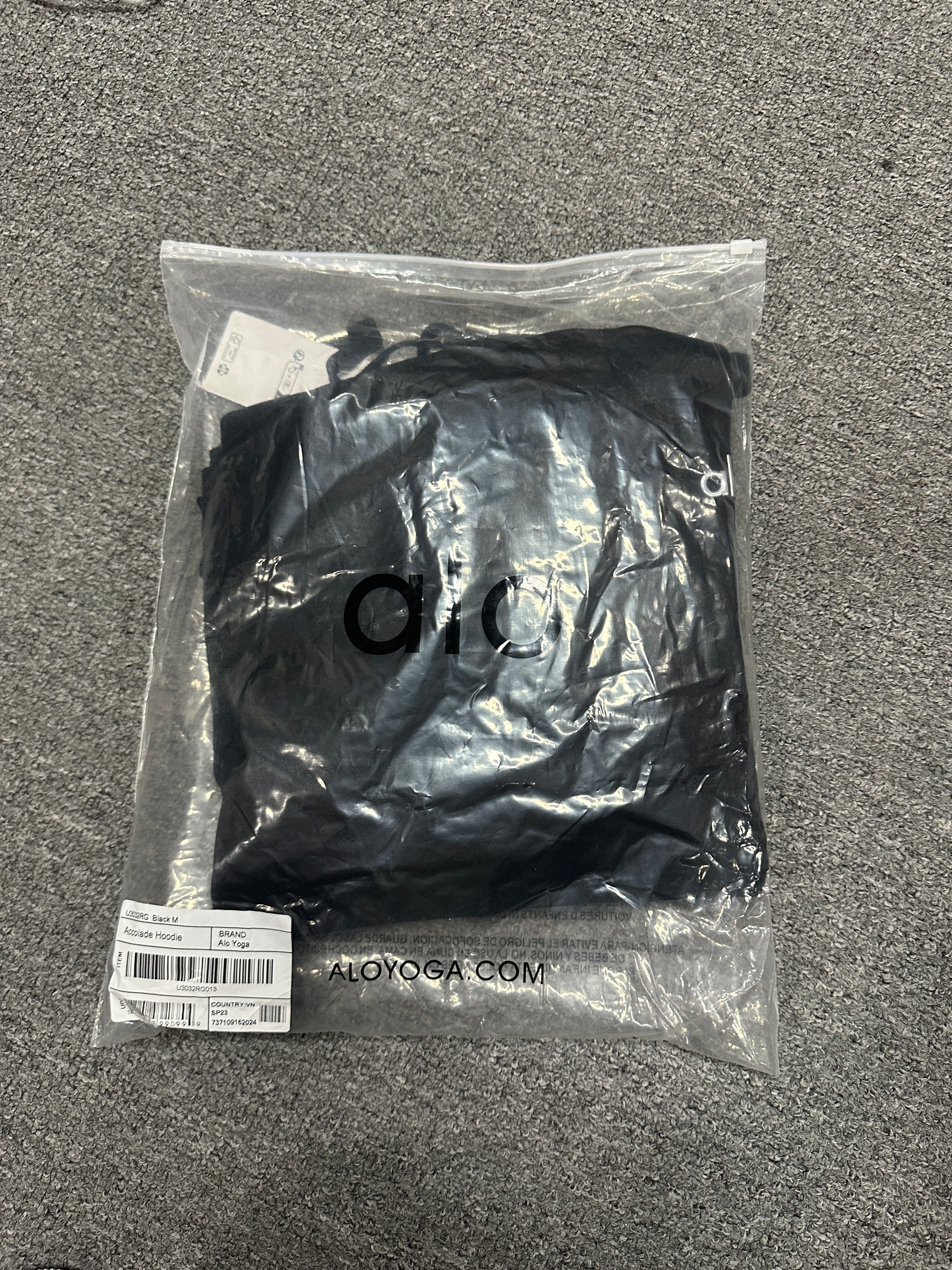 Embroidered ALO chest logo close-up on Black Accolade Hoodie