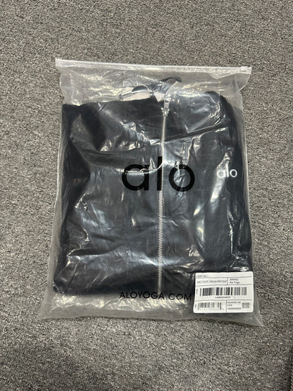 ALO Accolade Black full zip hoodie folded inside branded zip packaging bag