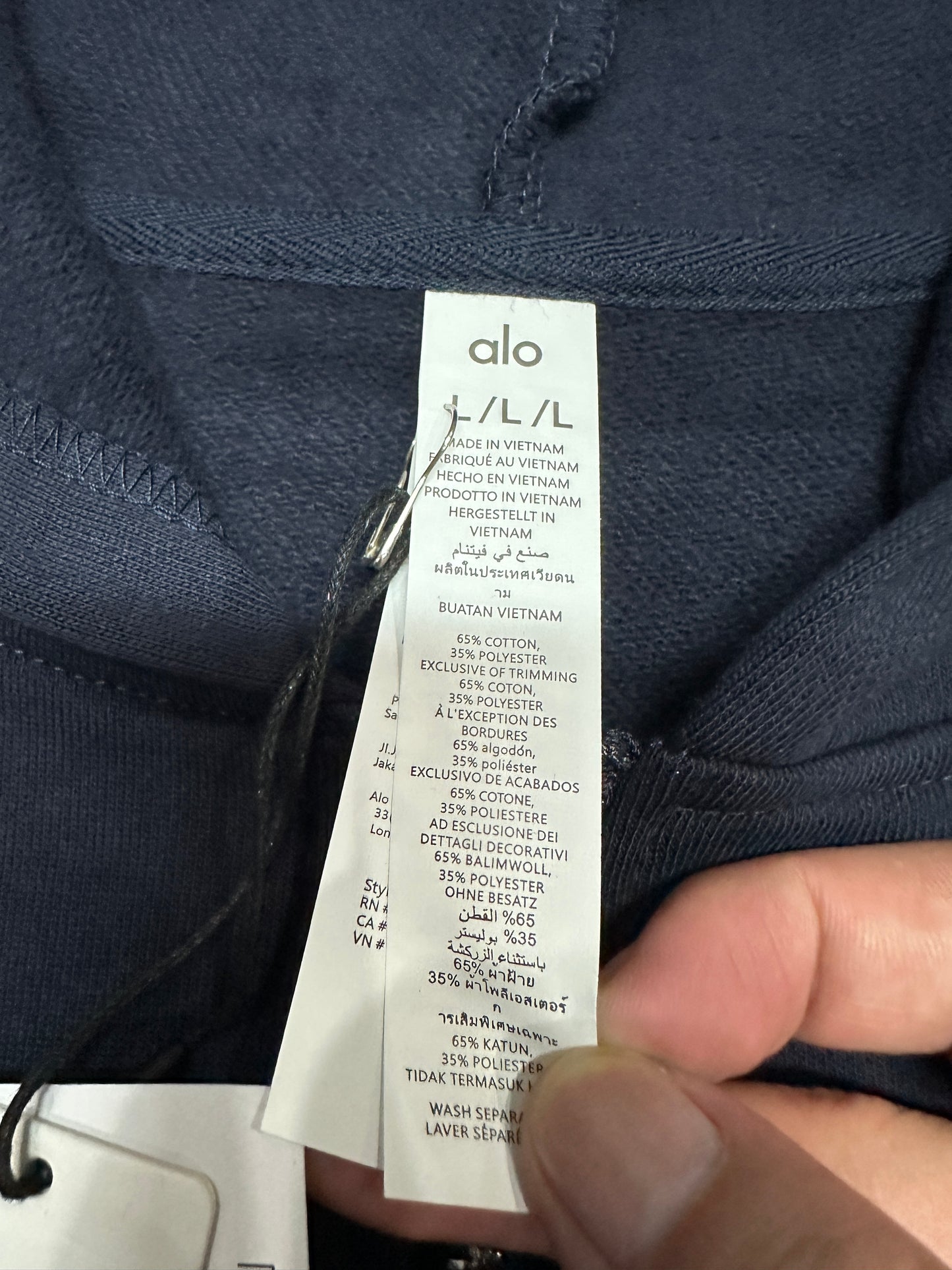 ALO Accolade Navy full zip hoodie neckline, hood and drawstring construction detail
ALO Accolade Navy full zip hoodie neck label close-up
ALO Accolade Navy full zip hoodie size label detail
ALO Accolade Navy full zip hoodie with branded retail hangtags