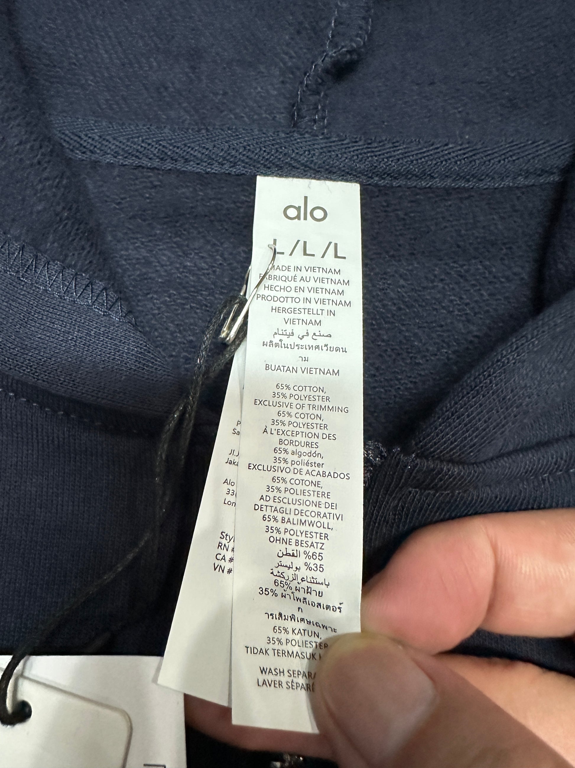 ALO Accolade Navy full zip hoodie neckline, hood and drawstring construction detail
ALO Accolade Navy full zip hoodie neck label close-up
ALO Accolade Navy full zip hoodie size label detail
ALO Accolade Navy full zip hoodie with branded retail hangtags