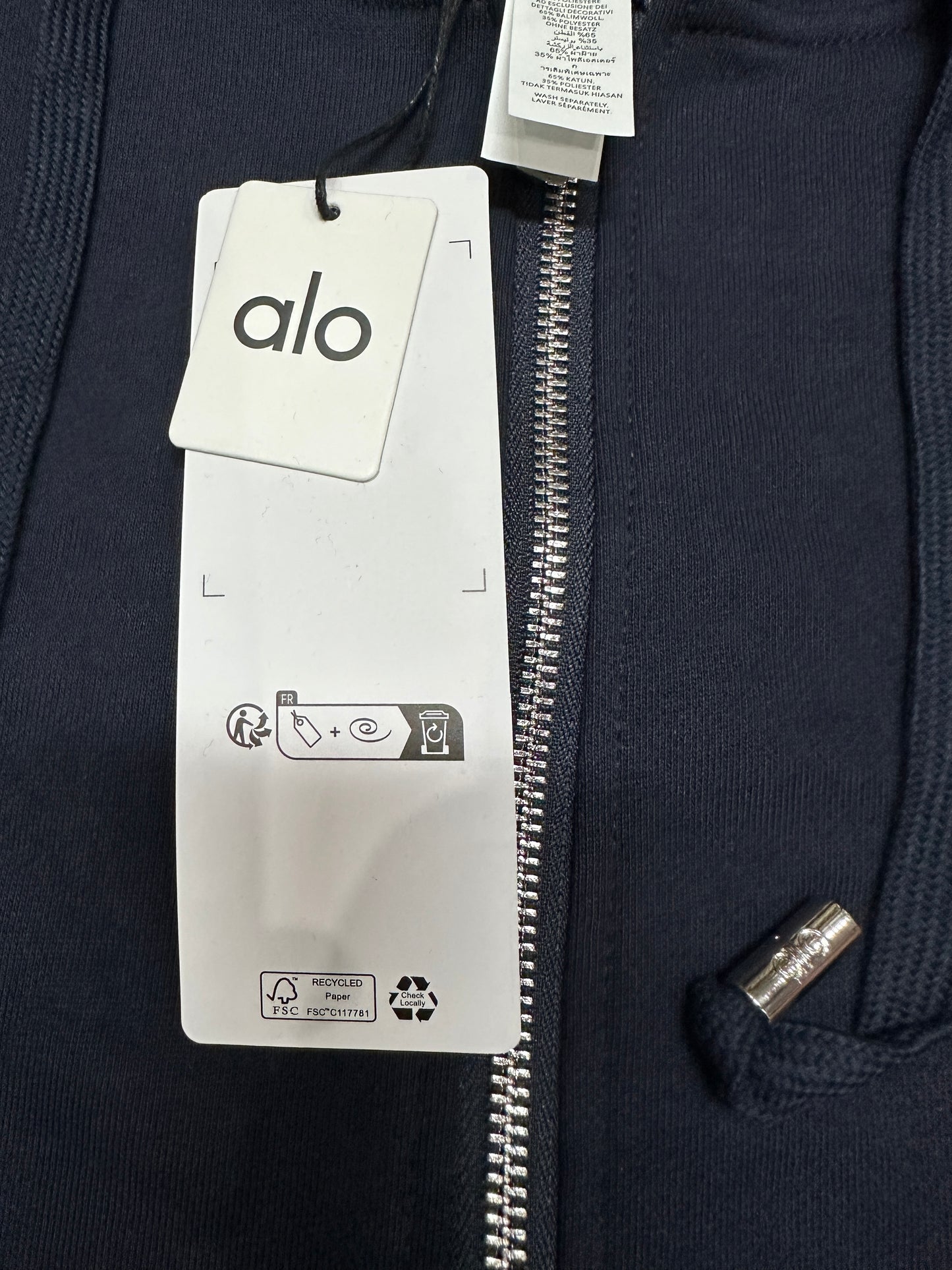 ALO Accolade Navy full zip hoodie neckline, hood and drawstring construction detail
ALO Accolade Navy full zip hoodie neck label close-up
ALO Accolade Navy full zip hoodie size label detail
ALO Accolade Navy full zip hoodie with branded retail hangtags